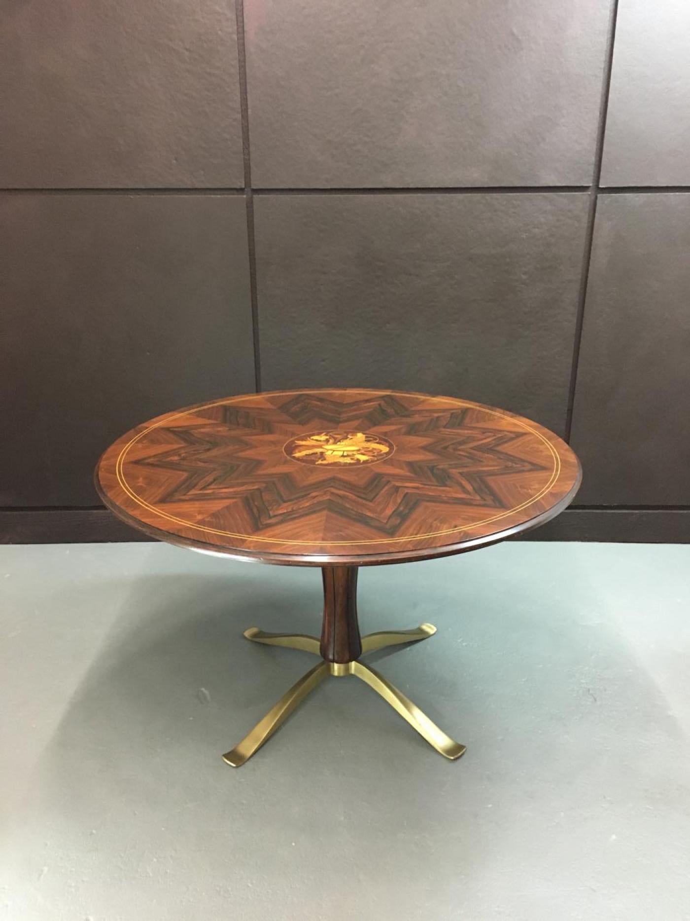 A rosewood and intarsia wood top rests on a carved rosewood pedestal with gilt bronze base. This beautiful table was designed by Paolo Buffa with central intarsia woodwork by Giovanni Gariboldi. Produced by Arrighi of Cantu. 
Italy,
1940s.