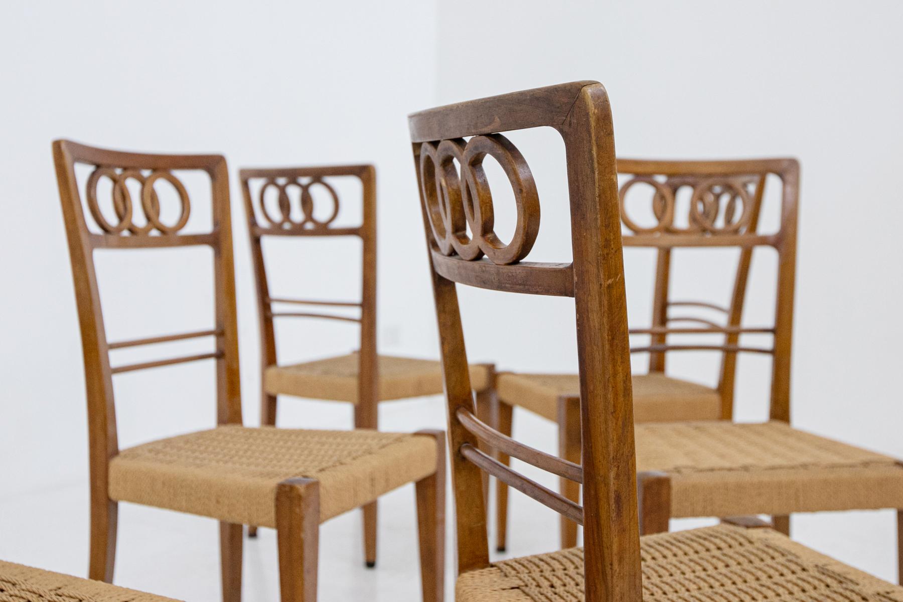 Elegant set of eight chairs by Attr. Paolo Buffa from the 1950s. The set is made of walnut wood. Its seat is made with woven ropes of straw. Their peculiarity is the wooden back carved with a circular pattern that creates a beautiful ornament to the