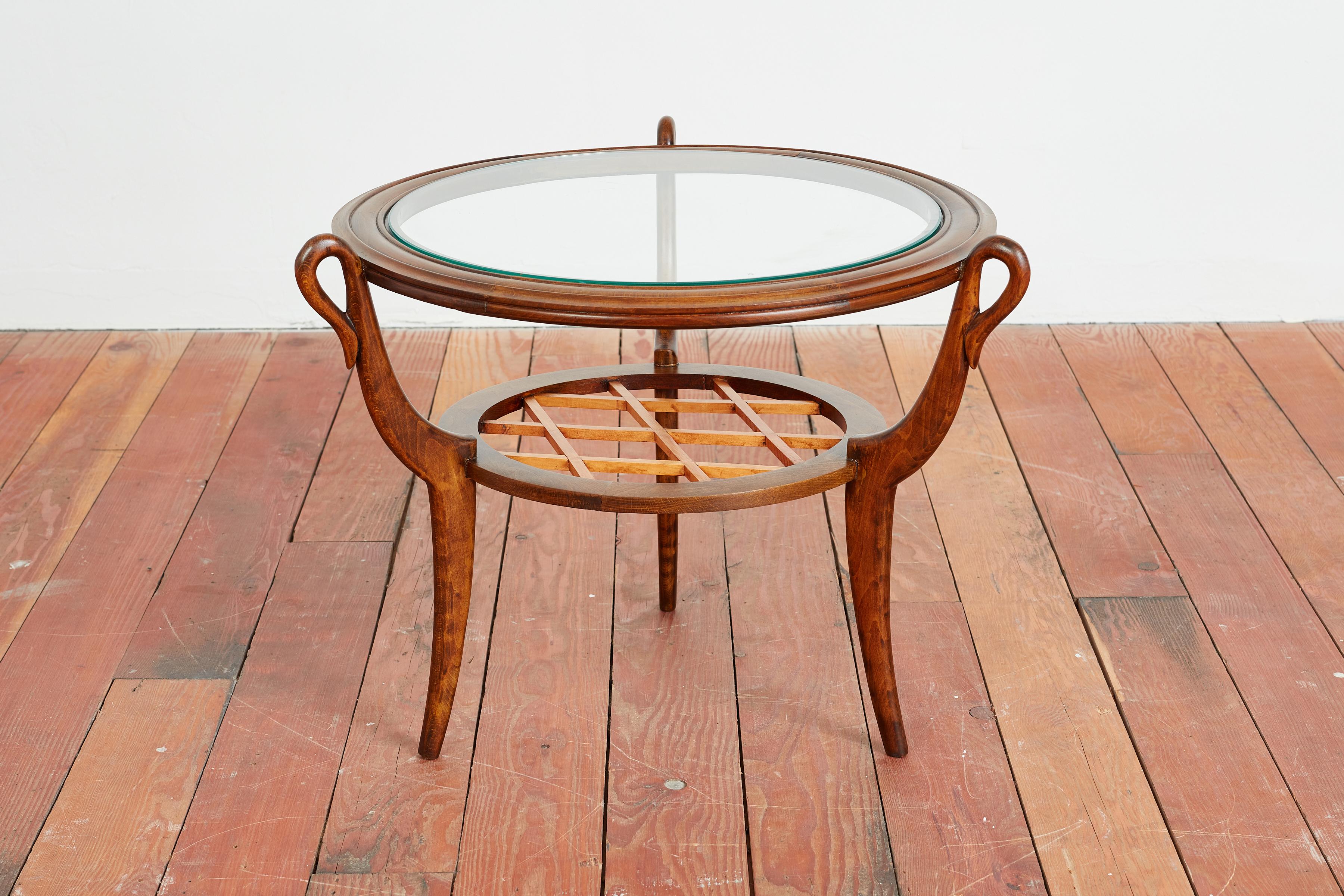 Table d'appoint élégante de Paolo Buffa - 
Italie, vers les années 1940 
Fabriqué en bois de noyer avec une étagère en bois tressé, de gracieux pieds courbés et un plateau en verre incrusté. 
Boucles circulaires à la jonction des jambes et de la