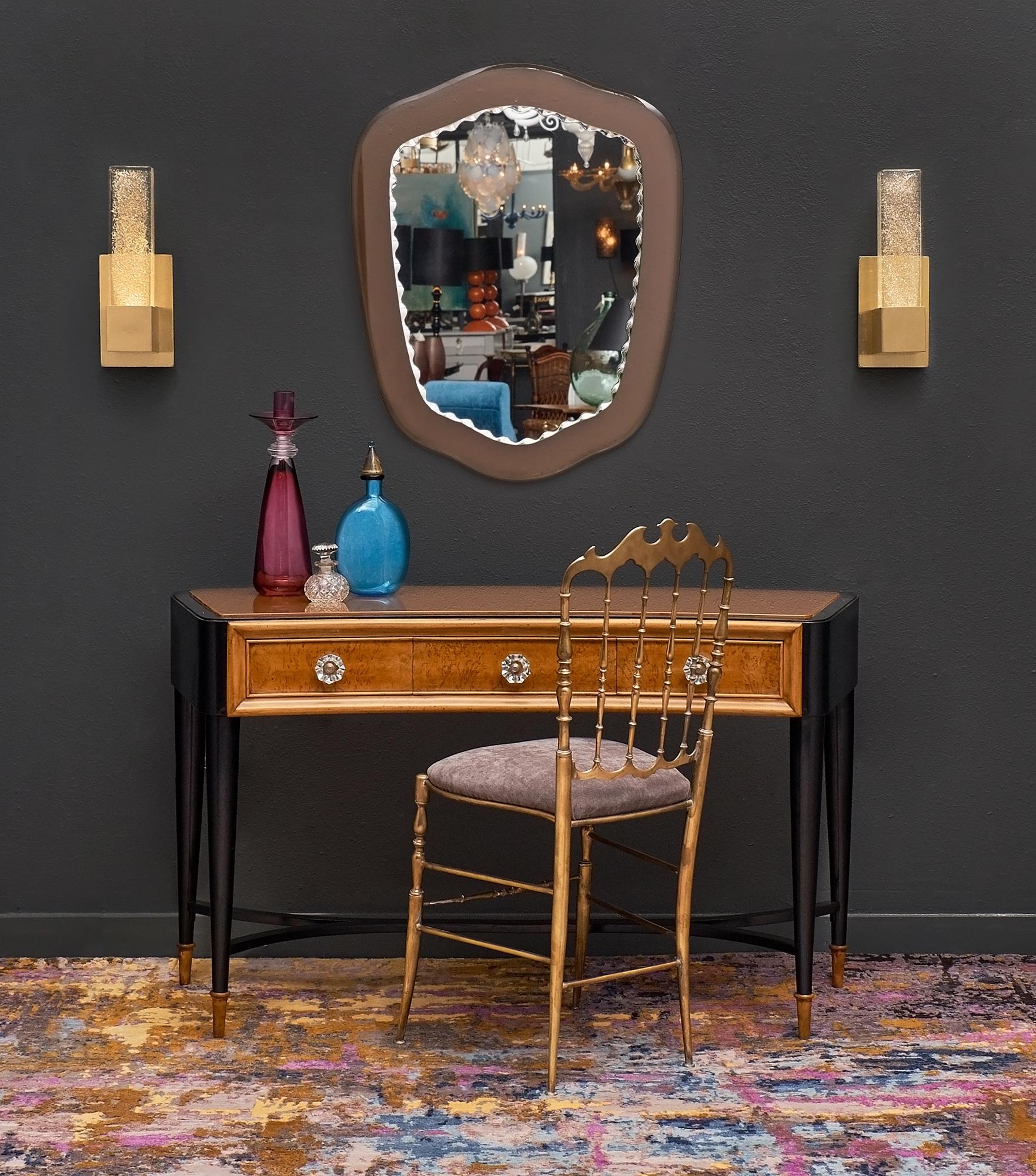 Italian console or vanity in the manner of Paolo Buffa with an elegant, curved shape. This piece features a tinted glass top original to the piece and three dovetailed drawers with original hardware. The tapered legs are connected with an