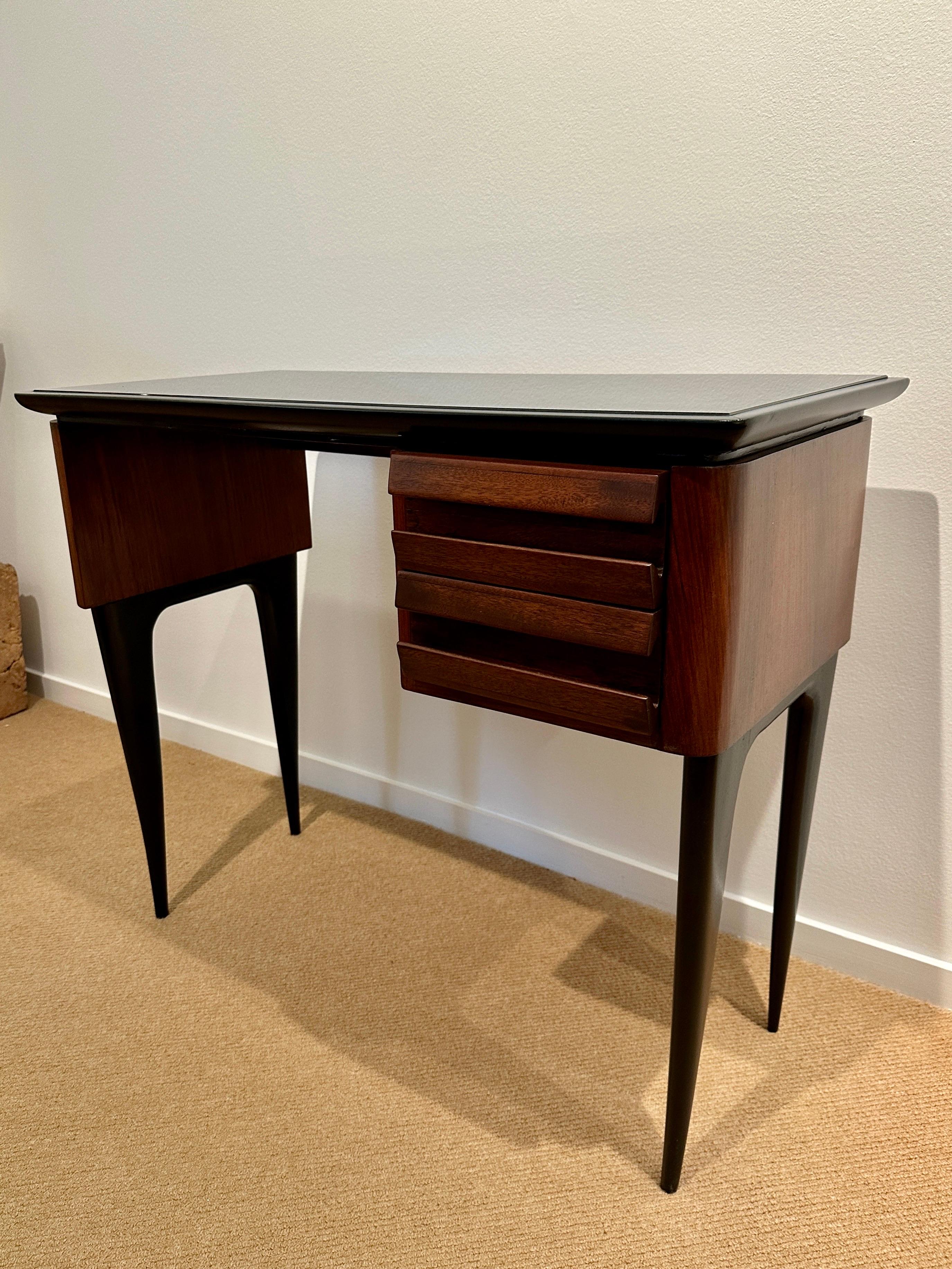 This very sweet writing desk with black glass plateau and two tone walnut and wood frame. Two small drawers.  THIS ITEM IS LOCATED AND WILL SHIP FROM OUR EAST HAMPTON, NY SHOWROOM.