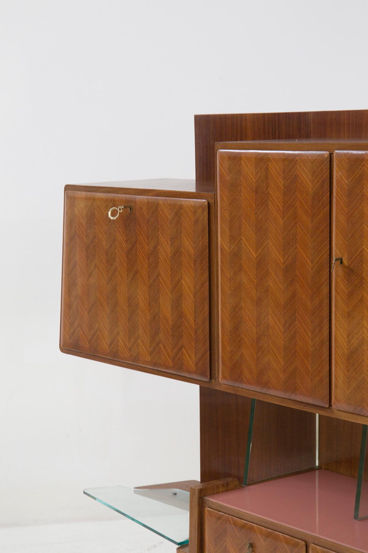 Splendid wooden wall cabinet attributed to the great designer Paolo Buffa in the 1950s, with Fontana Arte manufacture for the glass.
The cabinet has a base supported by 6 legs in Buffa's style, punched and quite thick, with an inverted triangular