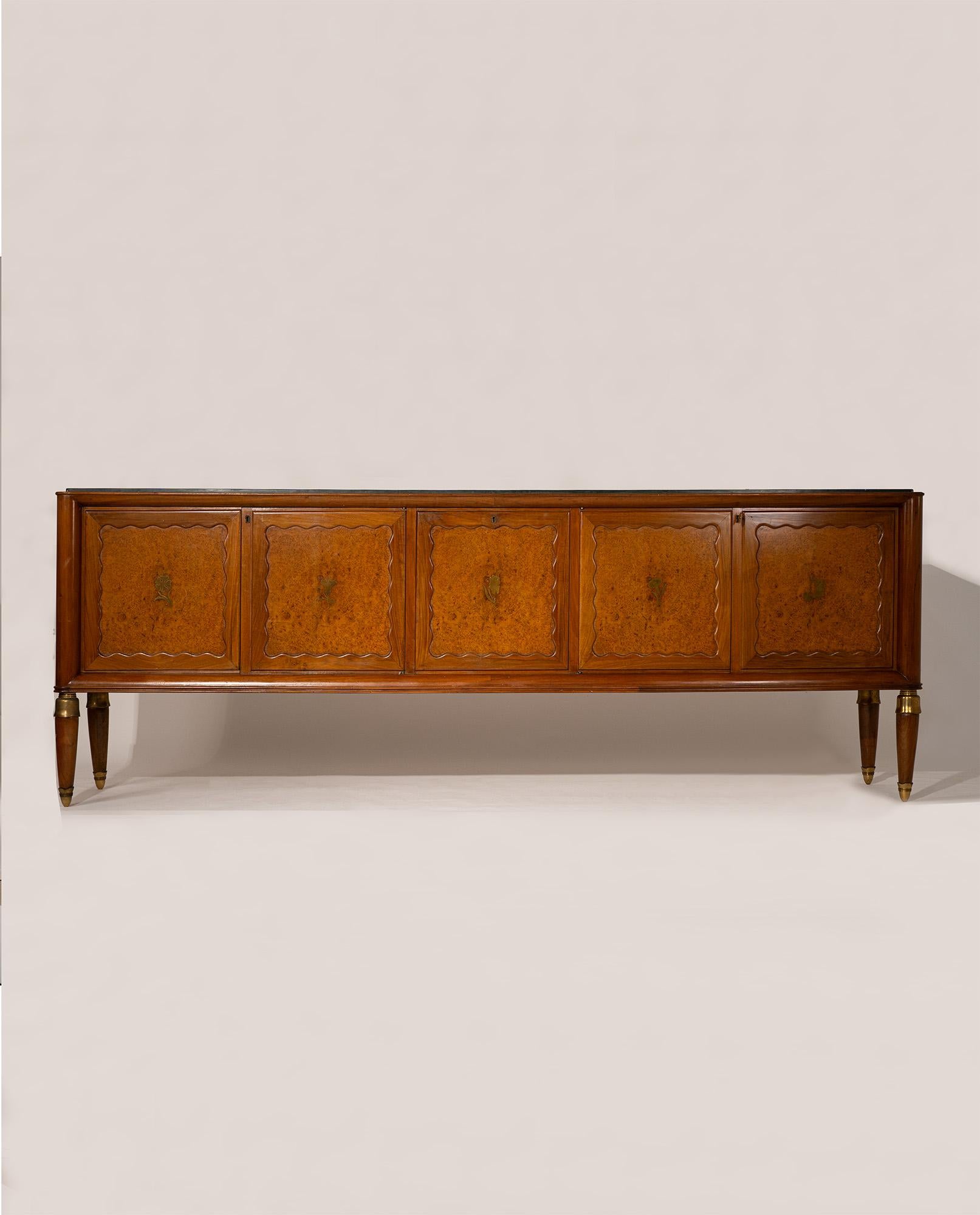 Designed by Paolo Buffa in 1956, this sophisticated Italian sideboard exemplifies the elegance and precision of postwar Italian craftsmanship. The cabinet features a luxurious green Alpine marble top resting above five doors in walnut and birch
