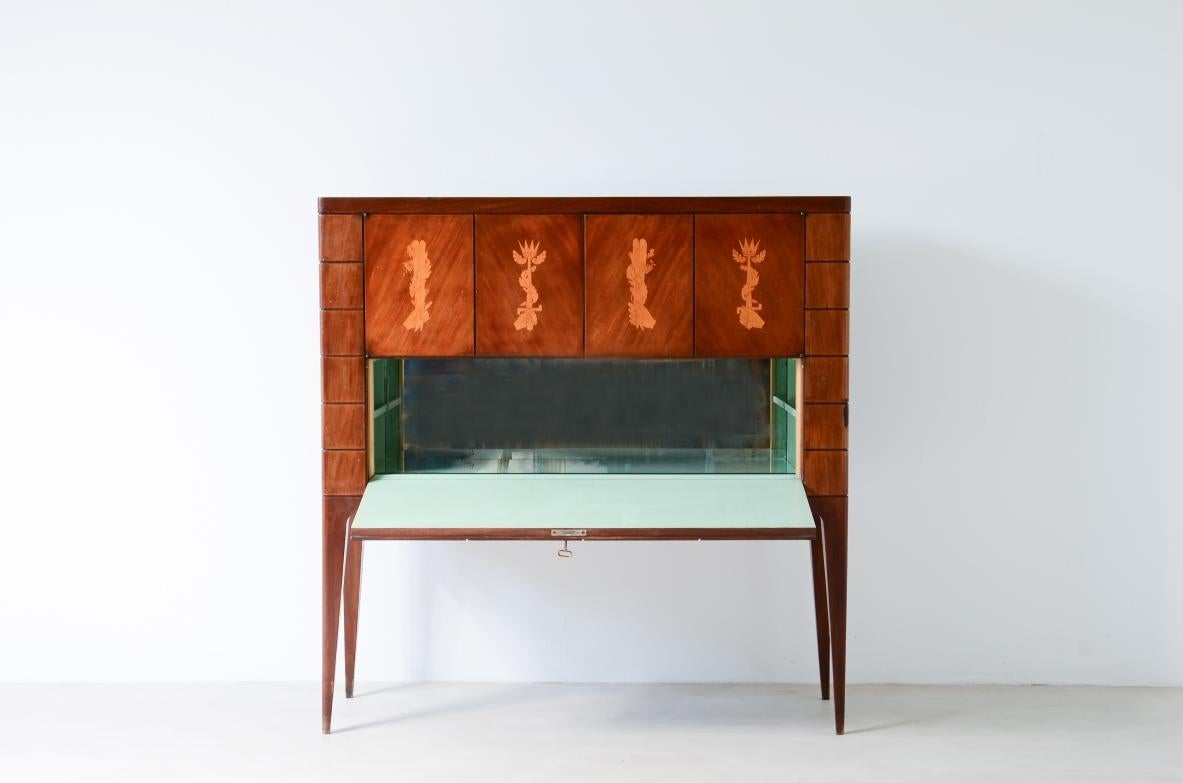 COD-2534
Paolo Buffa (1903-1970)

Rare meuble de bar en noyer avec façade en marqueterie d'érable et intérieur en métal laqué. Deux tiroirs en érable avec façades en verre, miroirs et lumière cachée. Dessins au recto par Giovanni