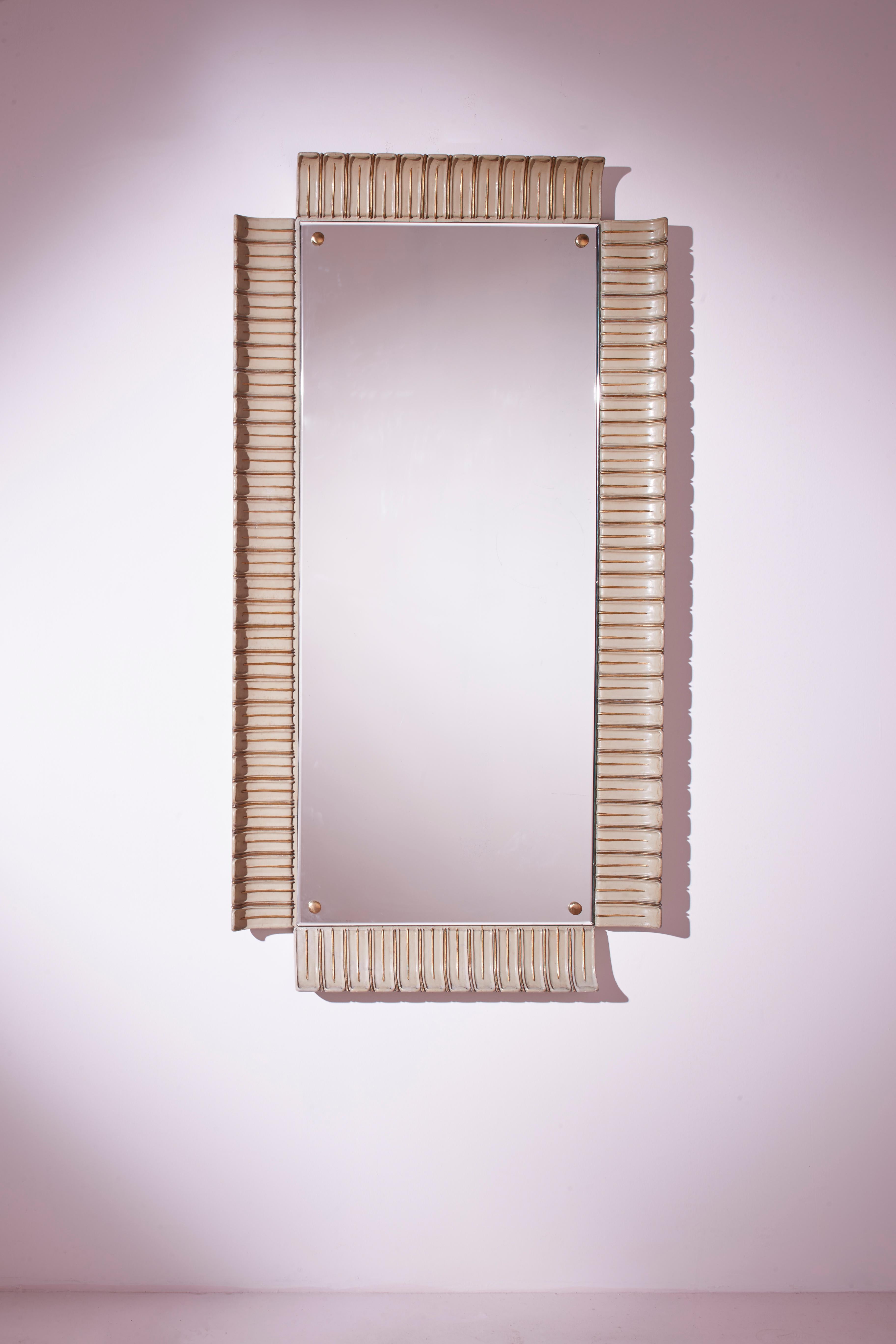 A rare and spectacular rectangular mirror with lacquered and gilded frame. Italian craftsmanship from the 1940s, designed by Paolo Buffa.

A large full-length mirror composed of an original glass from the 1940s, enhanced by a significant carved