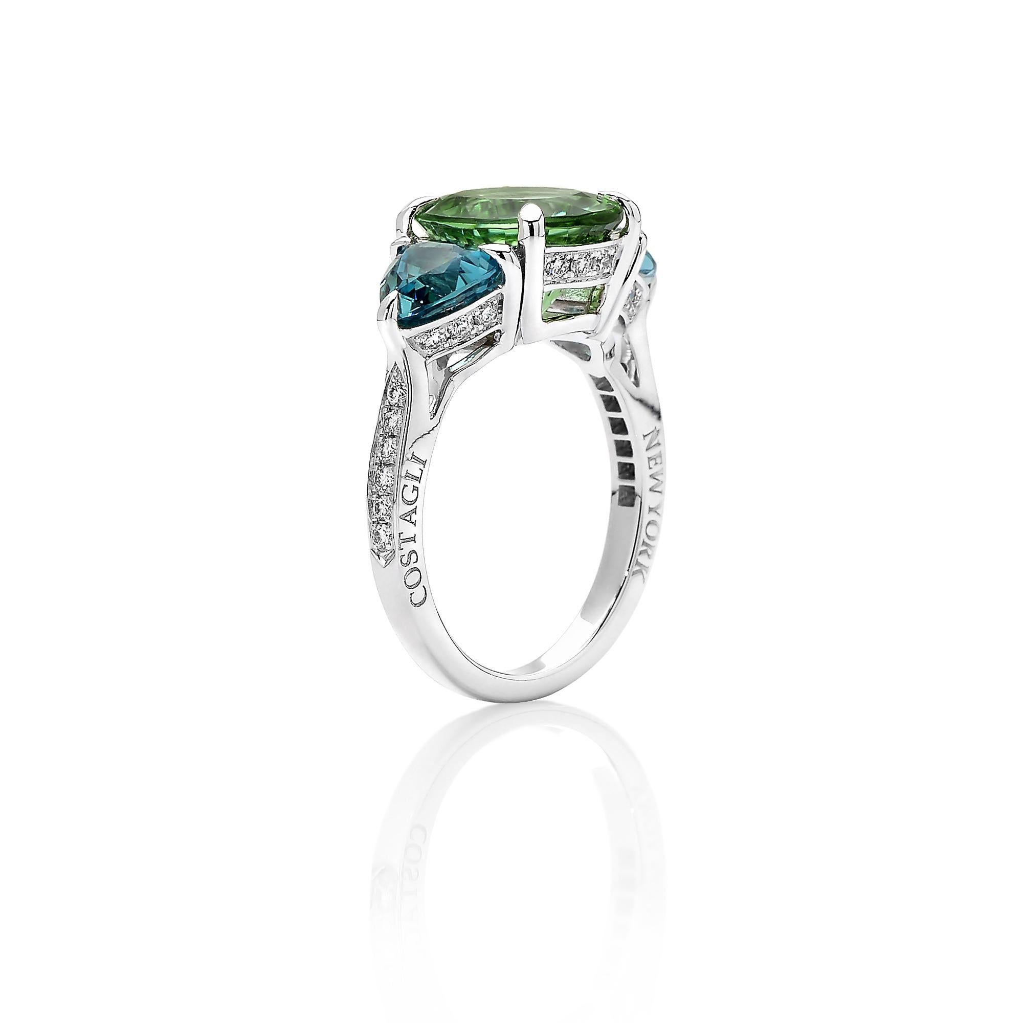 18 karat white gold ring featuring an oval-shape mint tourmaline flanked by two trillion-shaped blue tourmalines with round, brilliant diamond detailing. 

This ring is a testament to Paolo's expertise in color. The mint hue is further enhanced in