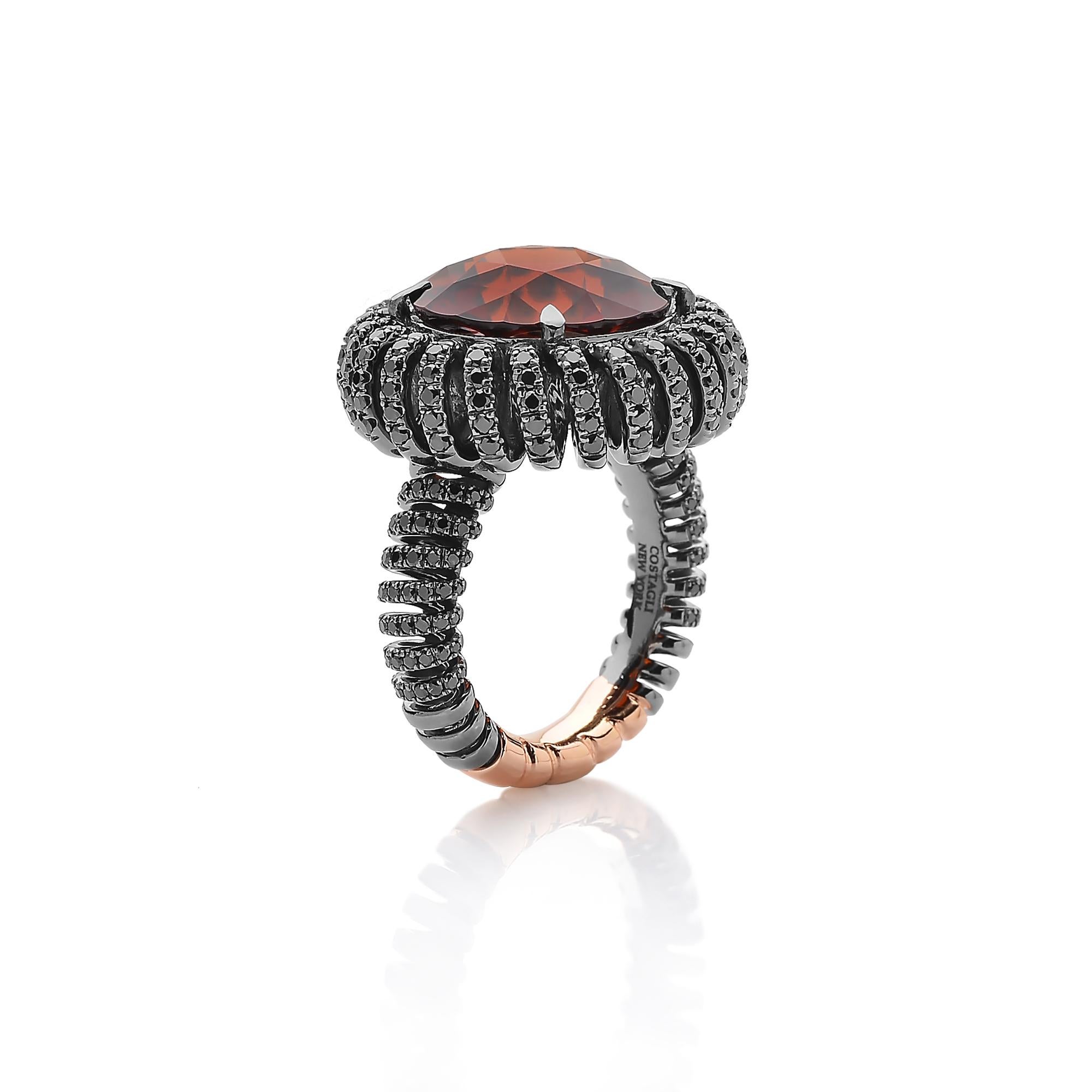 One-of-a-kind round hessonite garnet ring set in a continuous spiraled coil made of 18 karat white gold with black rhodium finish and pave-set black diamond detailing. 

The beauty is in the details - from the combination of hues, the cut of the