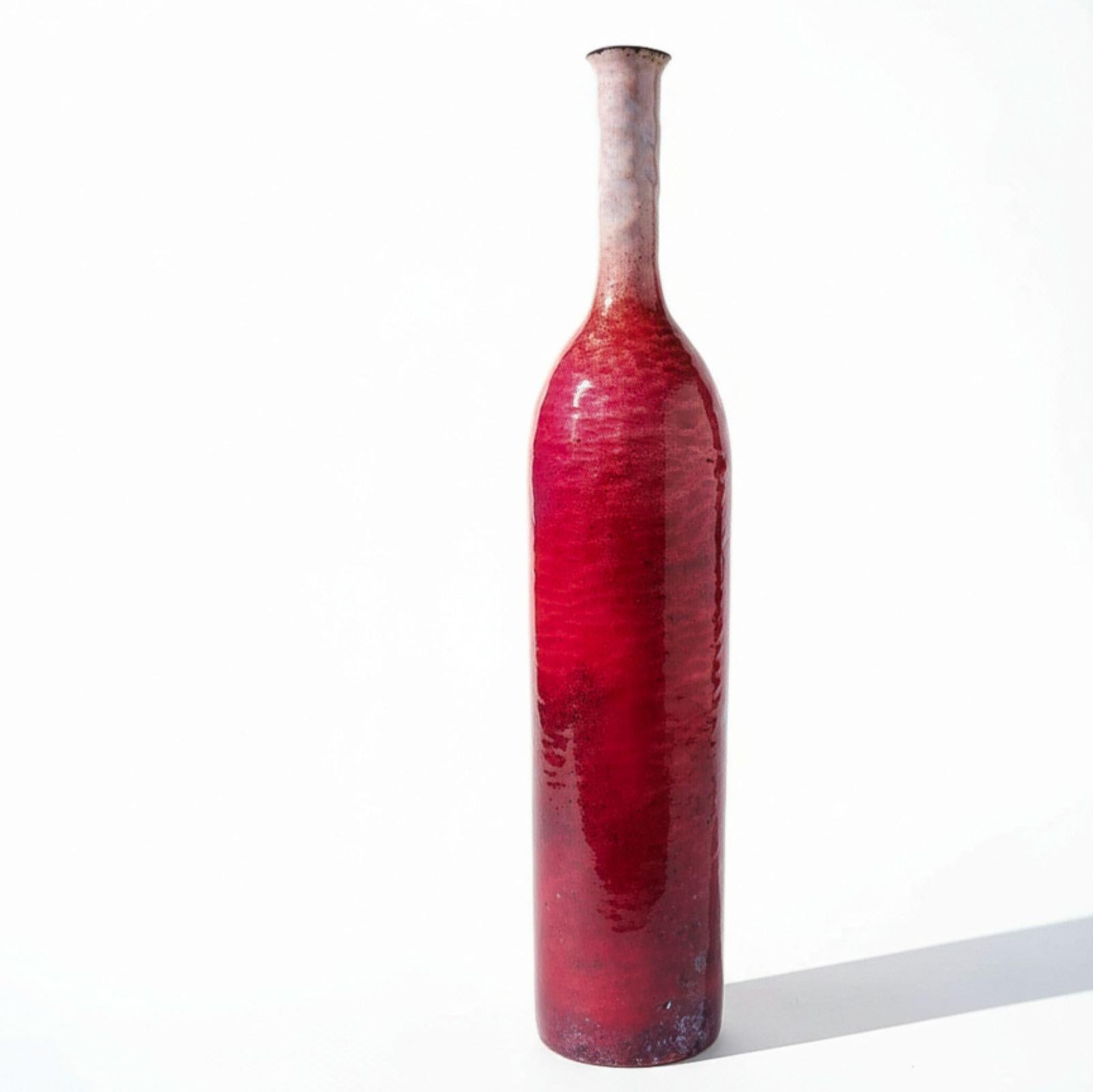 Vaso a forma di bottiglia in rame con superficie smaltata di Paolo De Poli. Il gradiente di colore passa con grazia dal rosso al bianco, dimostrando la padronanza della tecnica di smaltatura per la quale De Poli ha raggiunto il successo