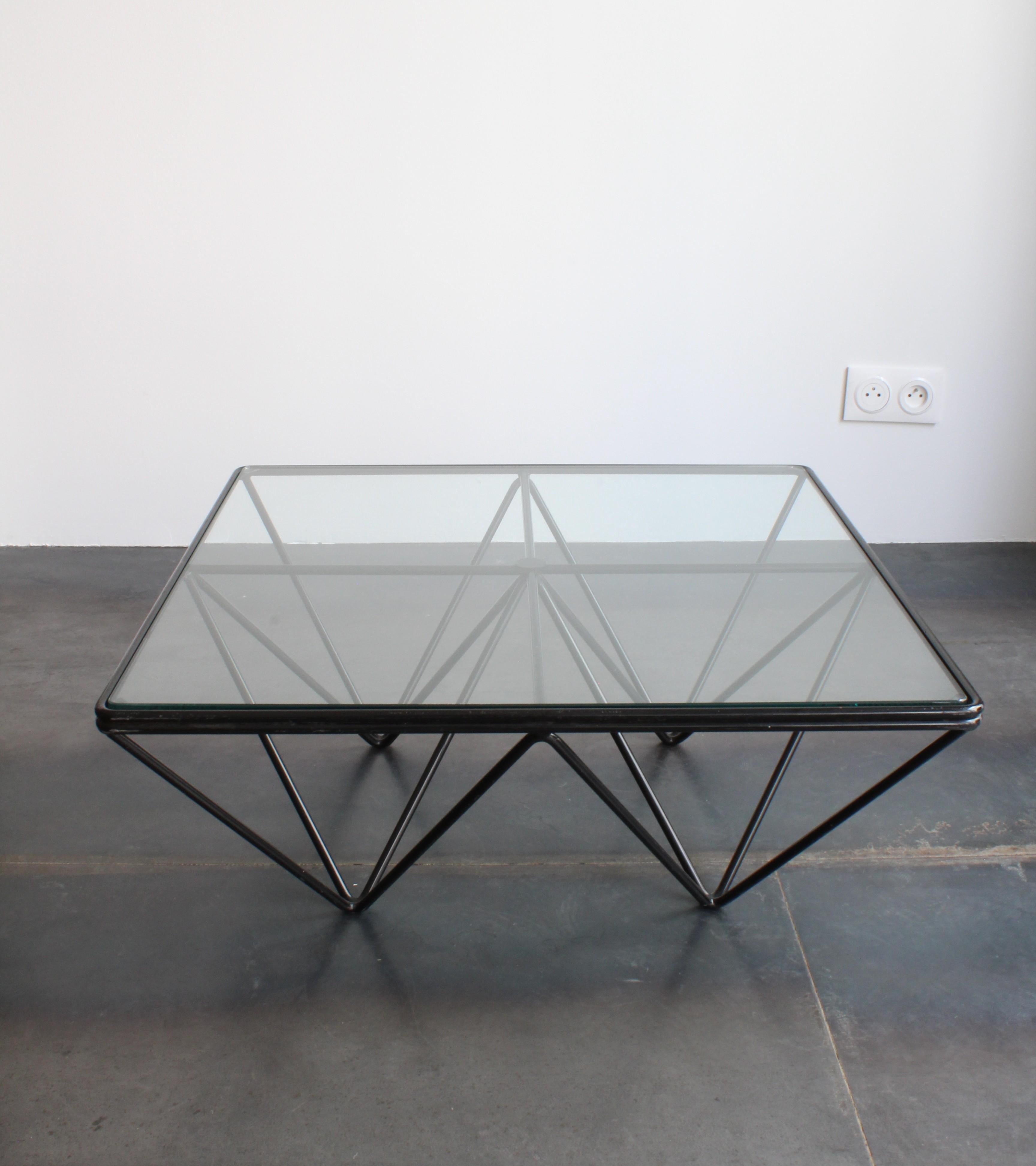 Der von Paolo Piva in den 1980er Jahren entworfene Tisch Alanda ist eine Ikone des modernistischen Designs. Sein geometrischer Sockel aus schwarzen Metallstäben, die dreieckige und pyramidenartige Formen bilden, schafft eine markante visuelle