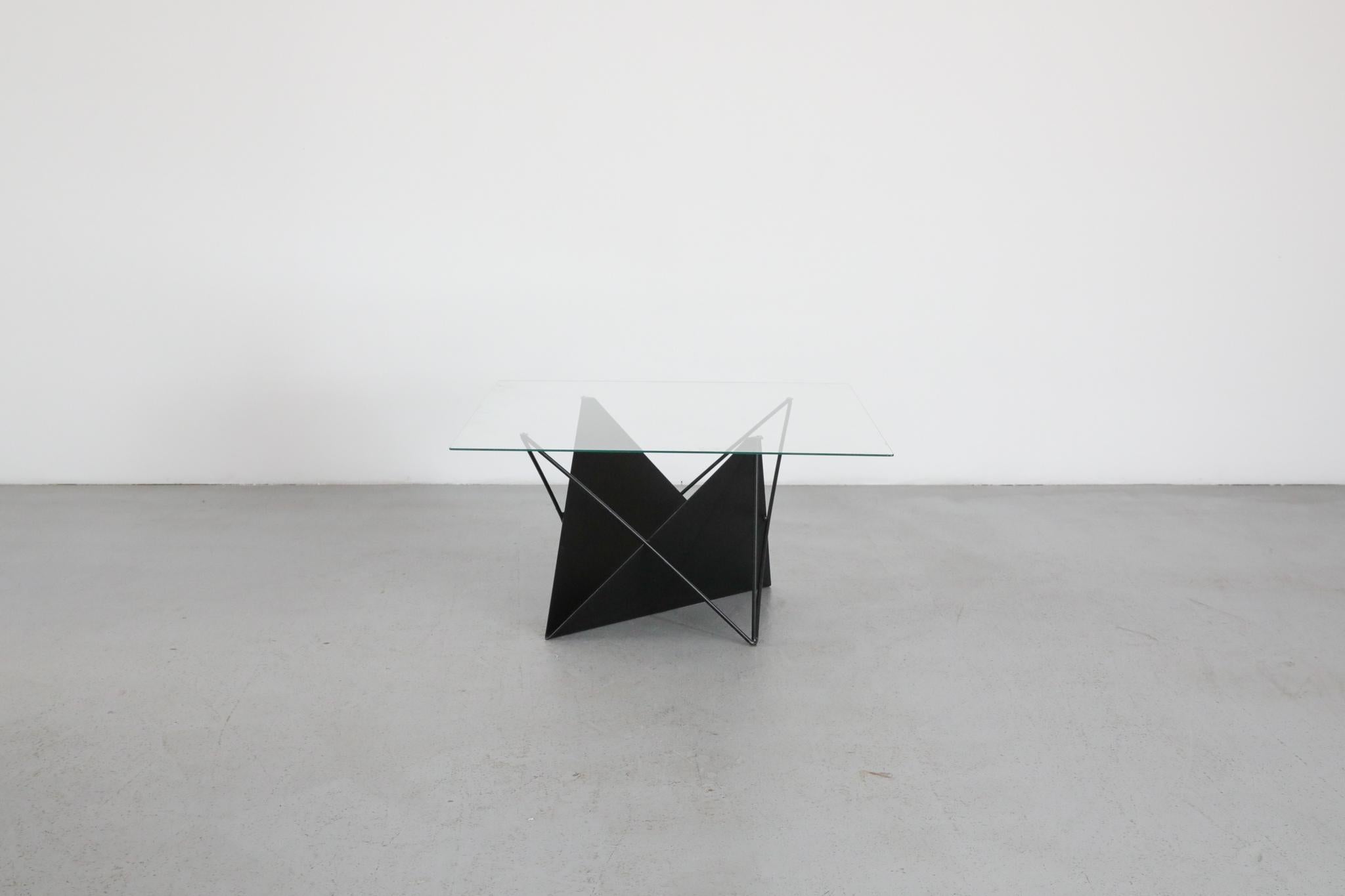 A striking Modernist coffee or side table inspired by the sleek, architectural designs of Italian designer Paolo Piva. This minimalist piece features a black enameled metal frame with clean, angular lines and an integrated angular metal magazine