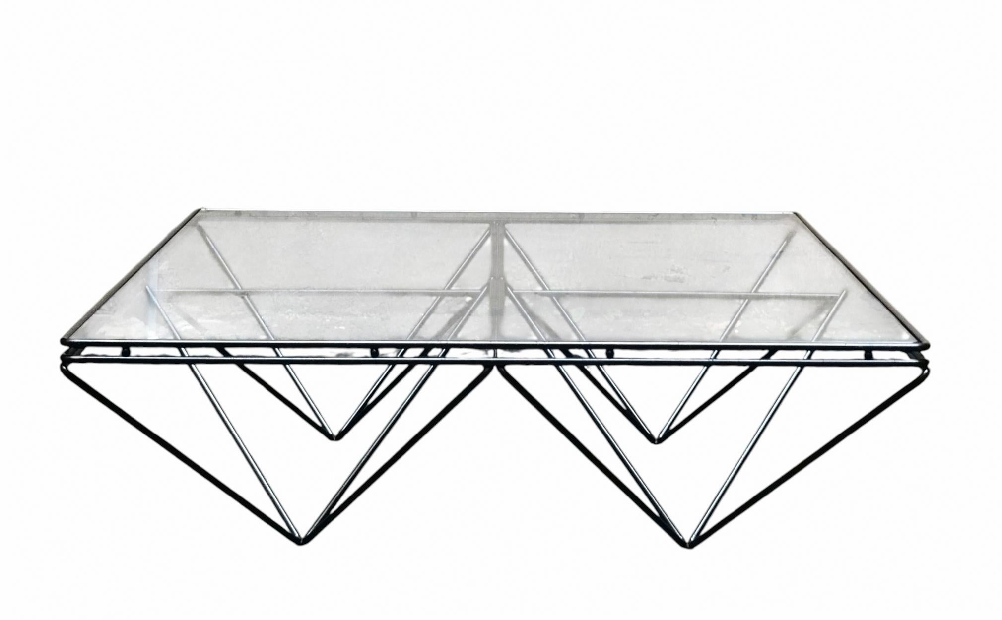 Tavolino dans le style de Paolo Piva pour Da Italia, caractérisé par une structure en tondino de métal verni noir et un piano en vetro trasparente. 
La base distinctive est une structure géométrique de piramidi rovesciate qui fonctionne à la fois