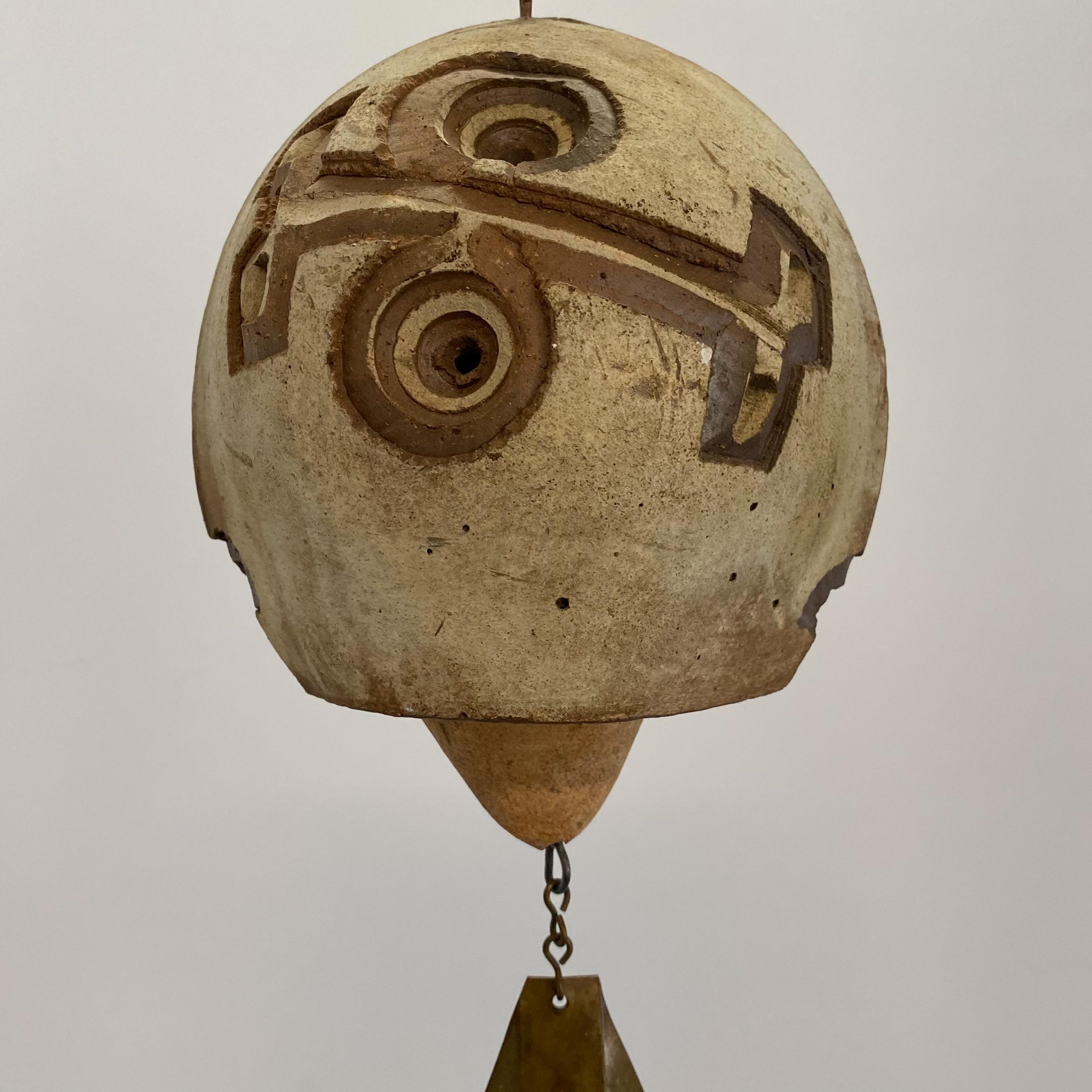 Clay chime with incised abstract motif, with clay clapper and copper fin. Designed by Paolo Soleri and hand-crafted at Arcosanti, c. 1960's. Minor wear to the clay but with no discernible cracks, hairlines, or chips--the bell still 