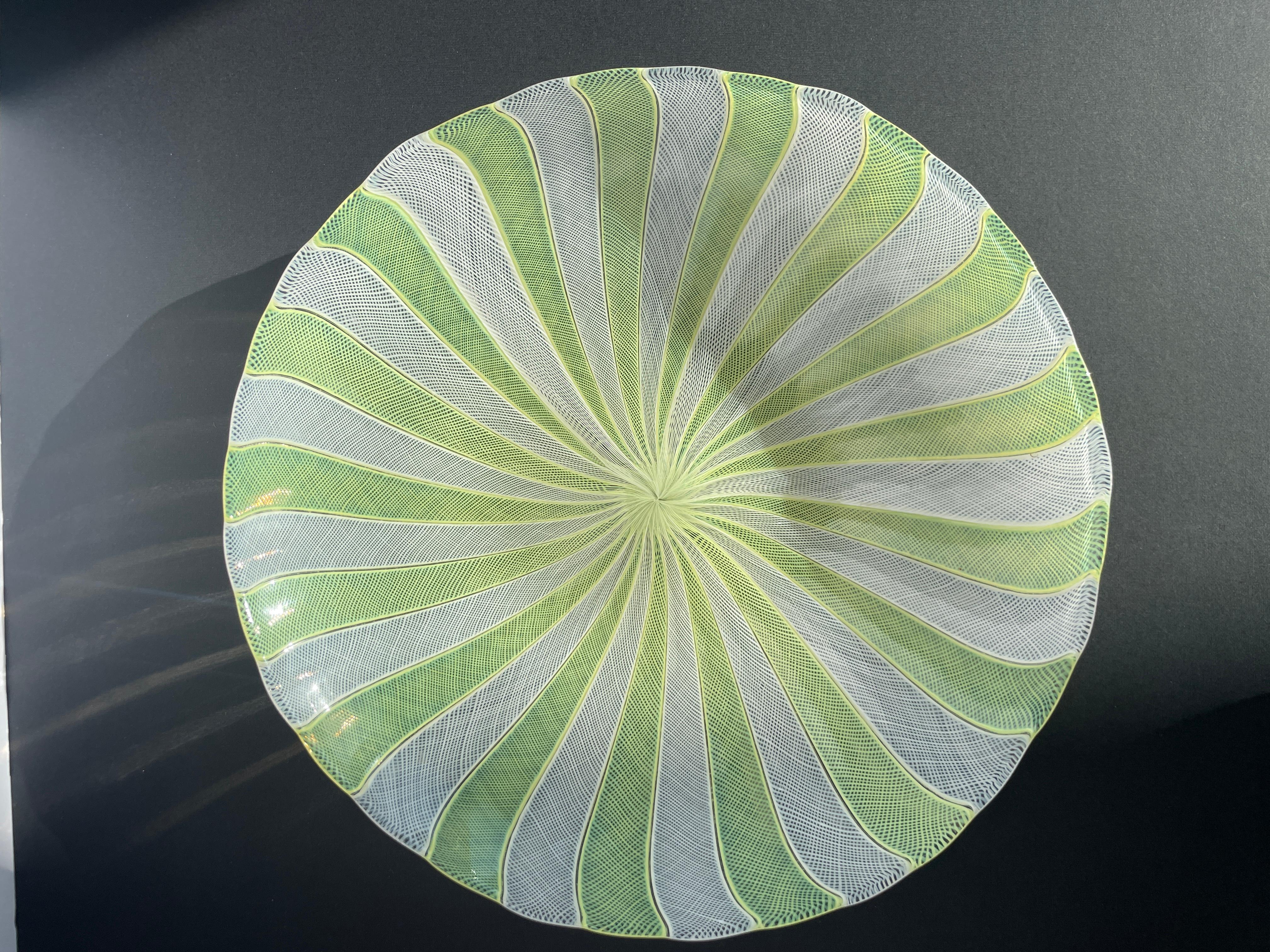 This elegant Murano glass bowl designed by Paolo Venini for Venini, is a masterful example of Mid-Century Modern Italian glass design, dating to circa 1950. Executed in a soft light yellow and white color palette, the bowl features intricate
