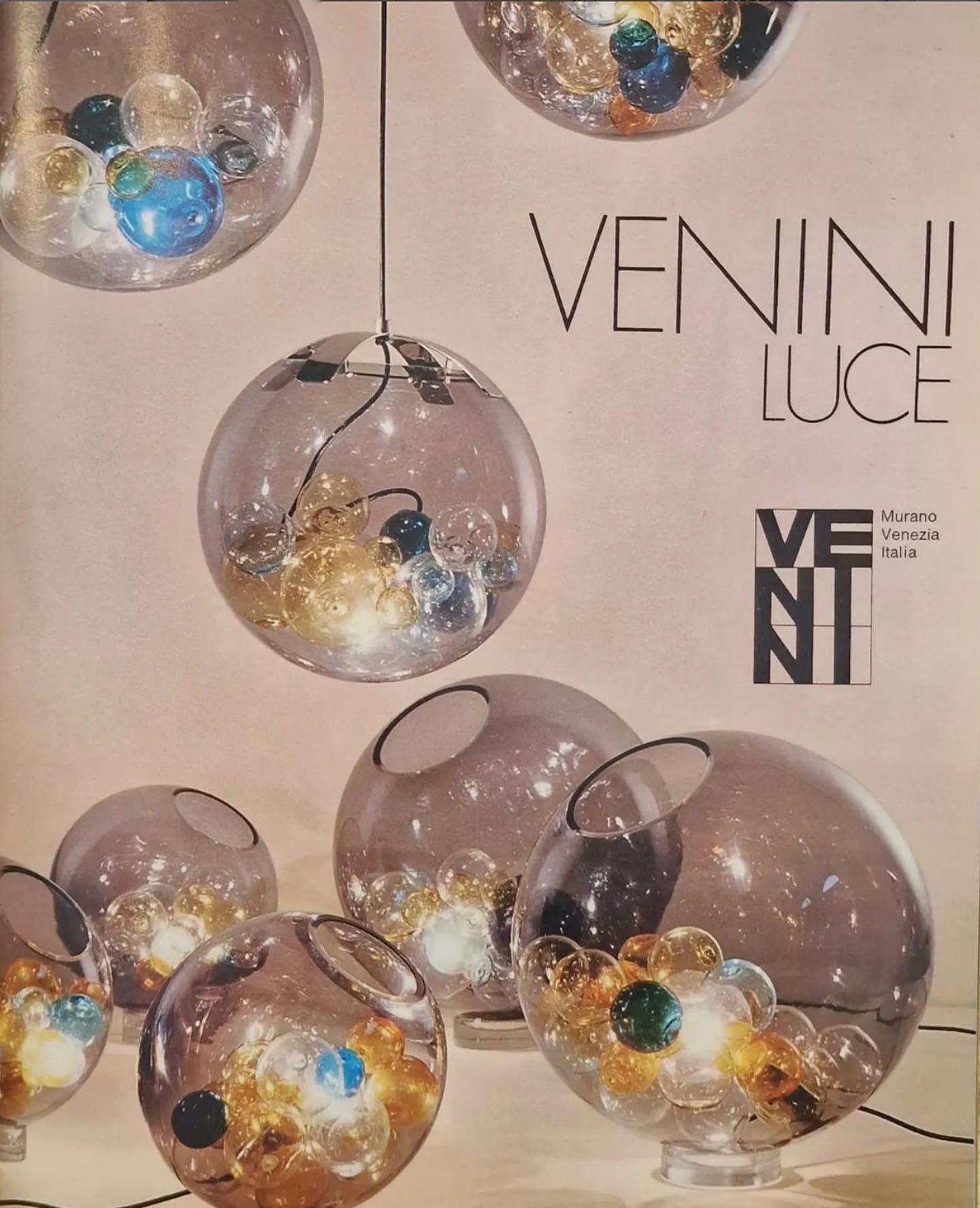 Studio Venini model 821 'Pallotta' table/floor lamp, Murano, Italy, circa 1966.

Smoke-coloured 'talpa' glass sphere with a bevel cut opening filled with an assortment of mouth blown glass ball bubbles in various hues and sizes.
32 Venini balls
8 @