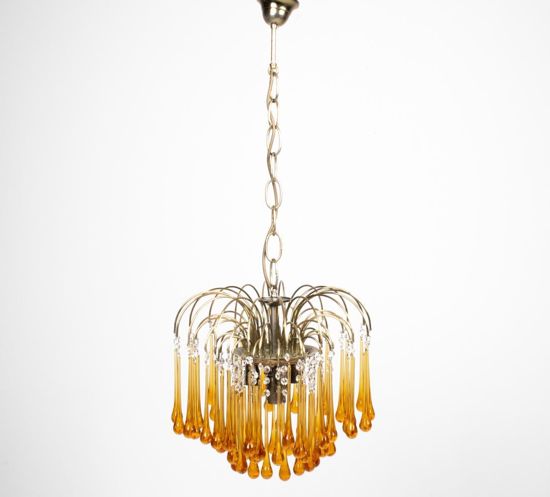 Petite yet powerful, this stunning chandelier by Paolo Venini bursts forth with an abundance of bold hand-crafted amber drops emanating from its gold-finished frame. Faceted clear crystal beads leading up to each drop add a classic touch to this