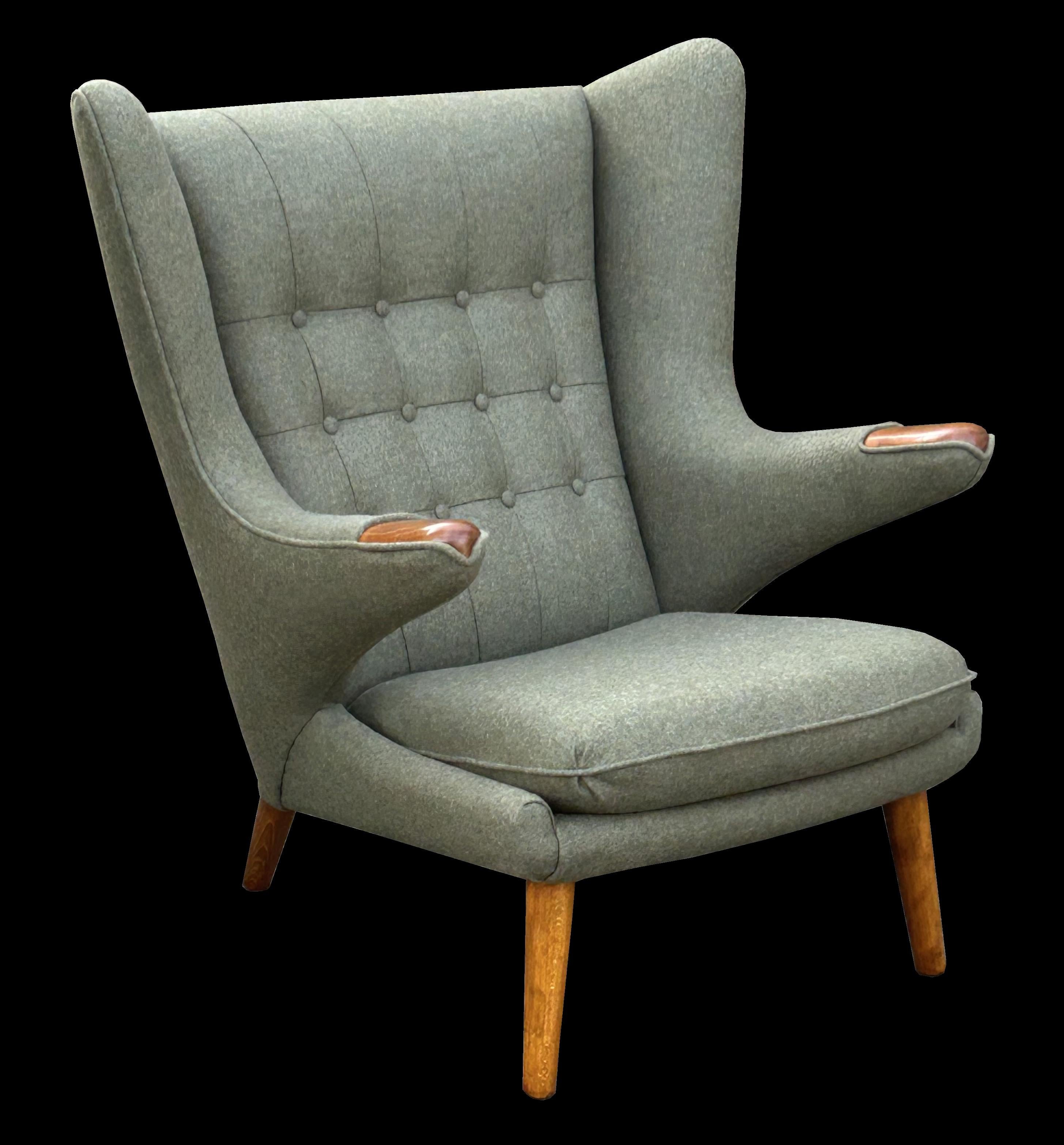 This is a beautiful example of an earlier version of the classic design by Hans J Wegner, and has been expertly reupholstered in Abraham Moon Forest Green fabric. The legs are of Oak and the 'bears paws', the pads on the tops of the arms are Teak.