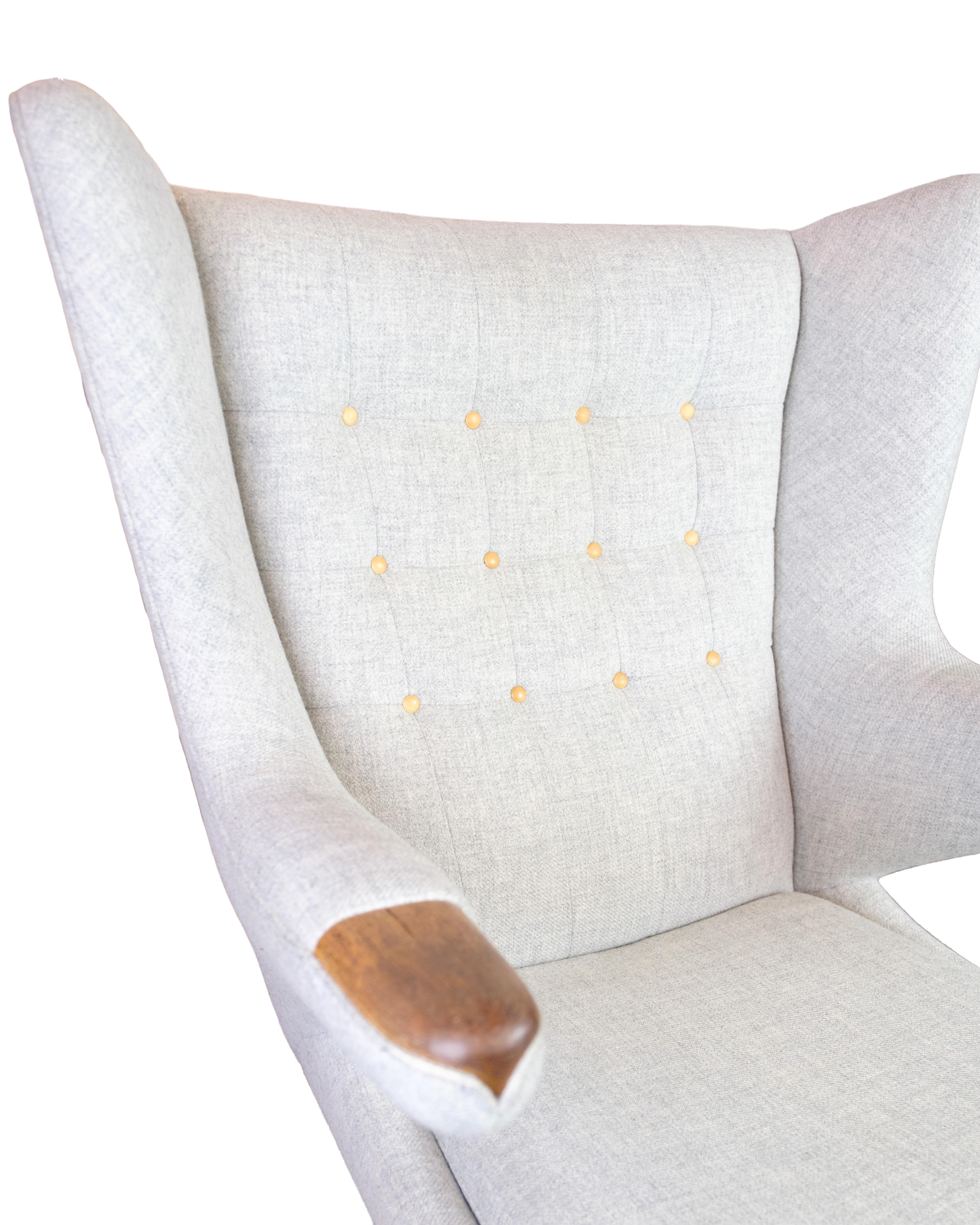 der Papa Bear Chair, Modell AP19, entworfen von Hans J. Wegner im Jahr 1951. Der Stuhl ist mit hellgrauem Hallingdal-Stoff gepolstert und hat Armlehnen aus massivem Teakholz. Ein Möbelstück, das skulpturale Formen mit außergewöhnlichem Sitzkomfort