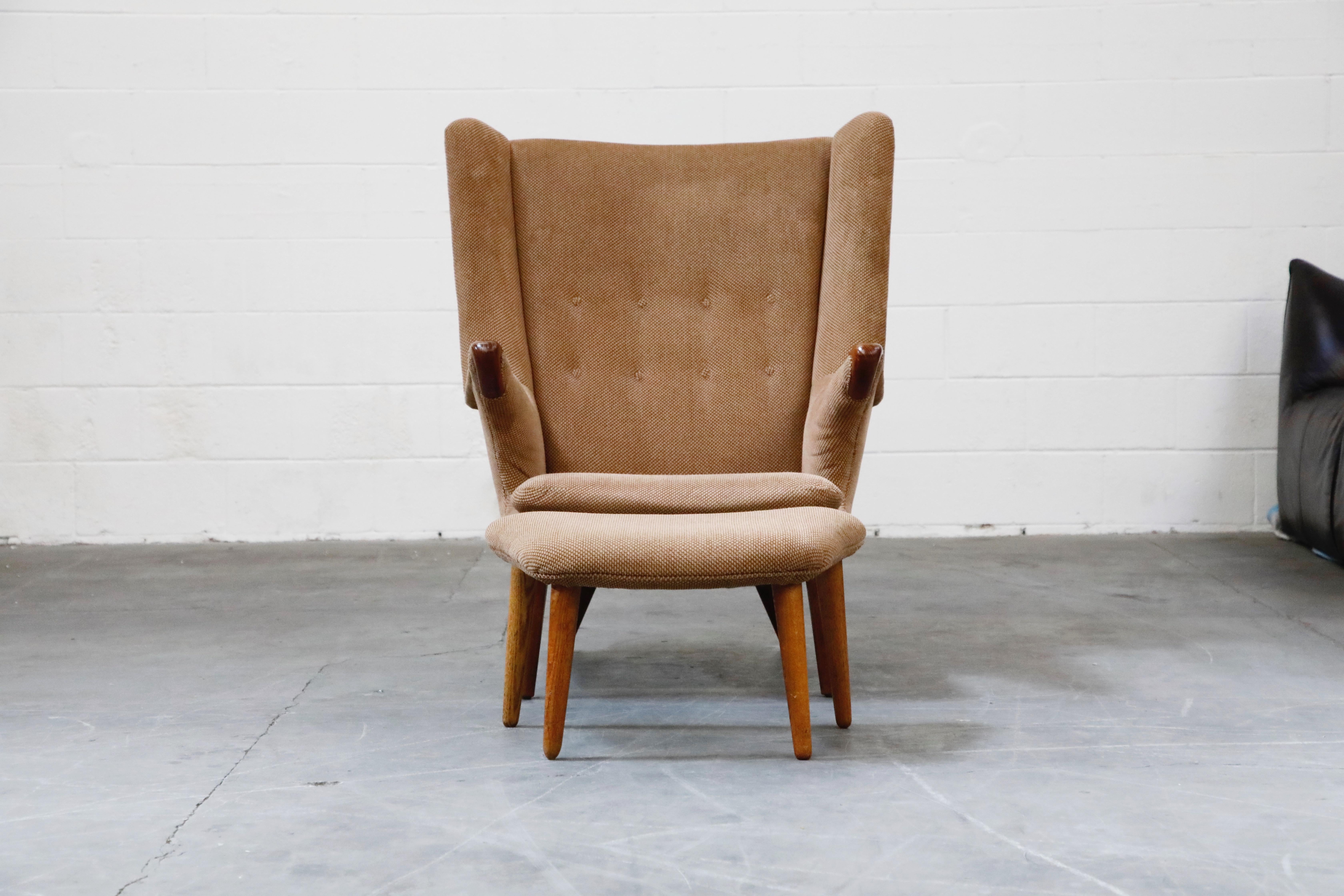 This beautiful teak and fabric model #91 'Papa Bear' wingback armchair and ottoman by Svend Skipper for Skipper Mobler was designed and made in the 1960s and professionally reupholstered in a soft, comfortable and attractive fabric in 1984 per the