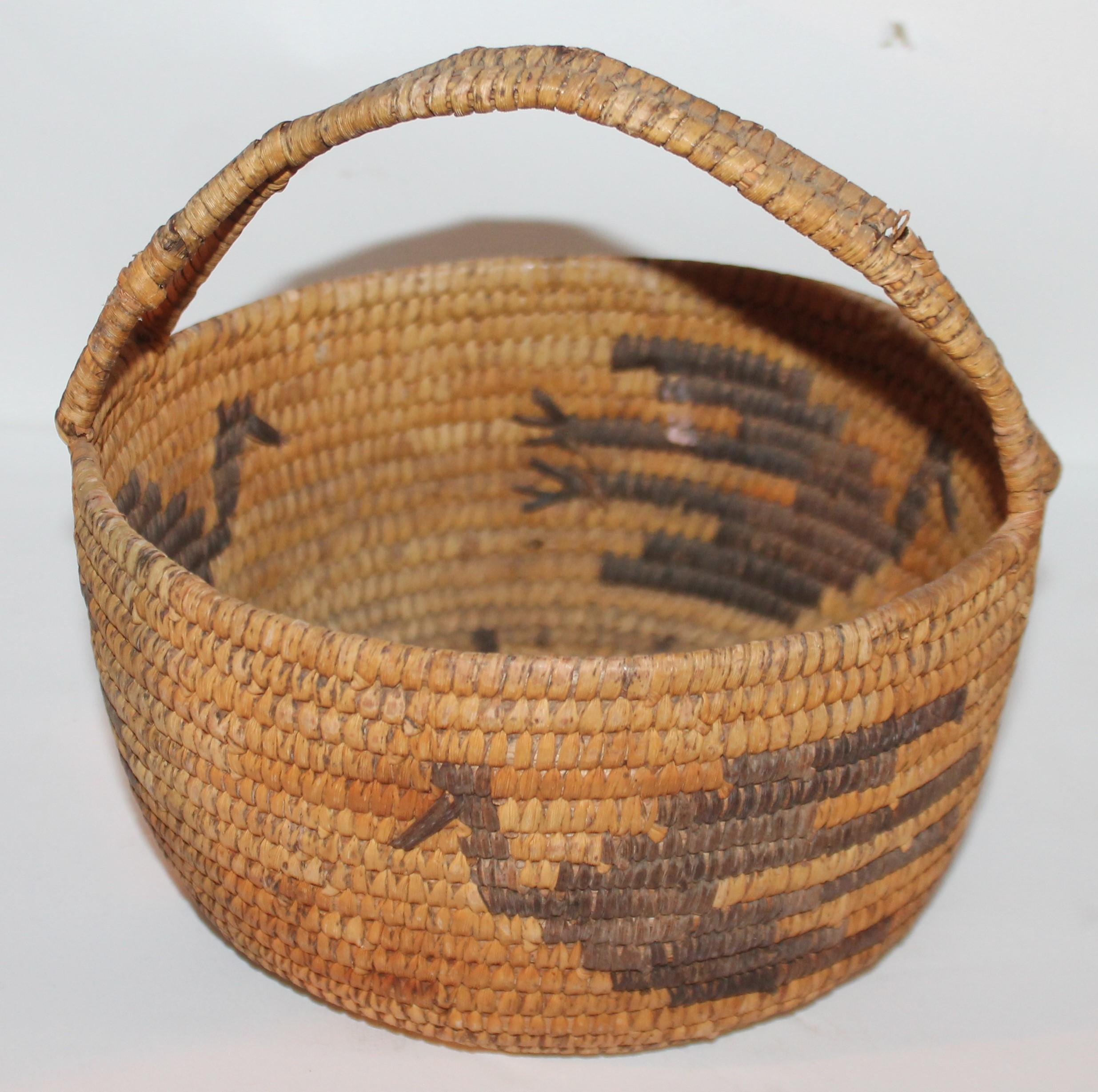 This Papago Indian handled basket is in good condition with a birds in flight. There are three birds total in flight.