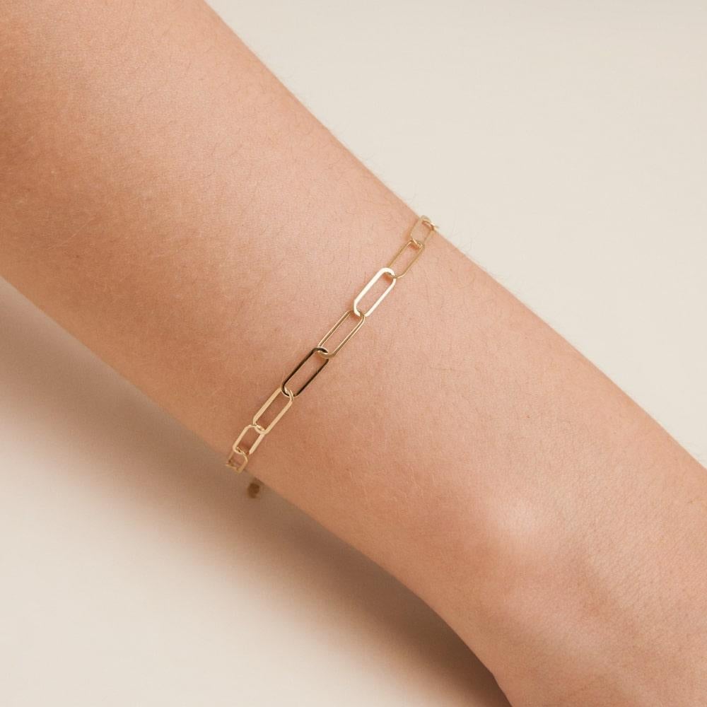 Introducing the 14K Solid Gold Paperclip Chain Bracelet, a shining example of Orena Jewelry's dedication to fusing traditional craftsmanship with contemporary design. Each bracelet is created with meticulous attention to detail, offering a sleek