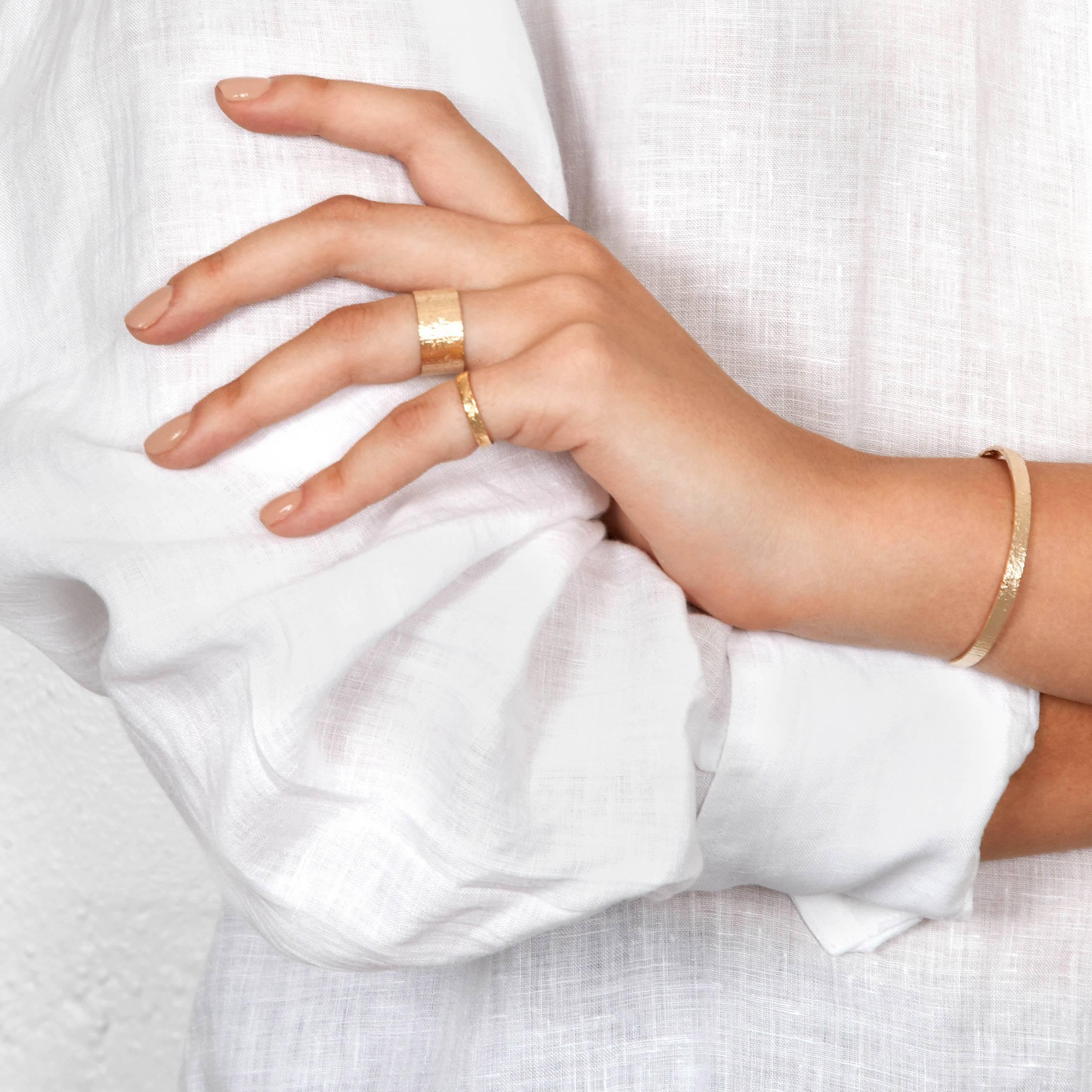 This simple band ring features a rustic shimmering texture handcrafted in 9-carat yellow gold.  This ring is made to order; please allow 2-3 weeks for production.

Every piece in this collection is individually hand-crafted in paper and cast