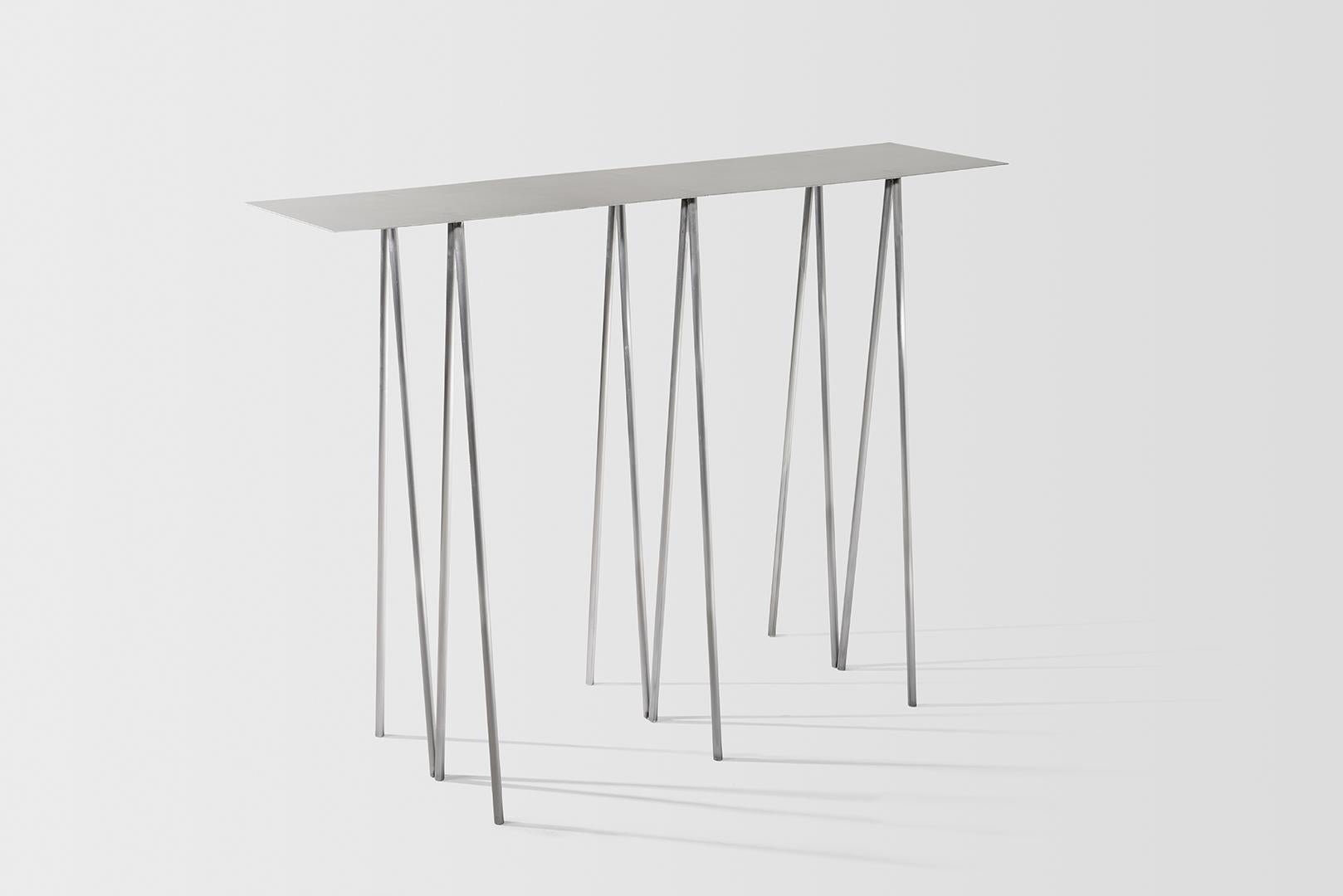Where metal implies sturdiness, and calls for strong industrial motifs - the I/ the H, the beam / the cross, the Paper Table is a play on our own sense of balance. 

It questions the thinness of both surface and structure, in order to reach their