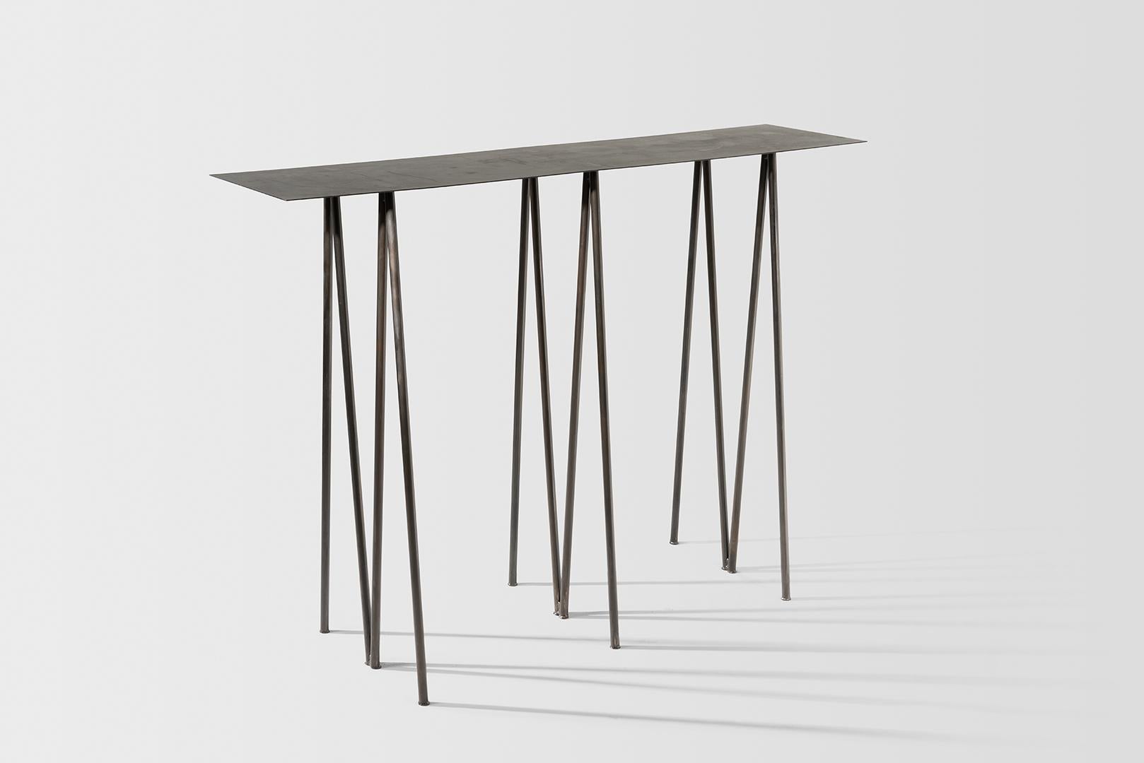 Where metal implies sturdiness, and calls for strong industrial motifs - the I/ the H, the beam / the cross, the Paper Table is a play on our own sense of balance. 

It questions the thinness of both surface and structure, in order to reach their