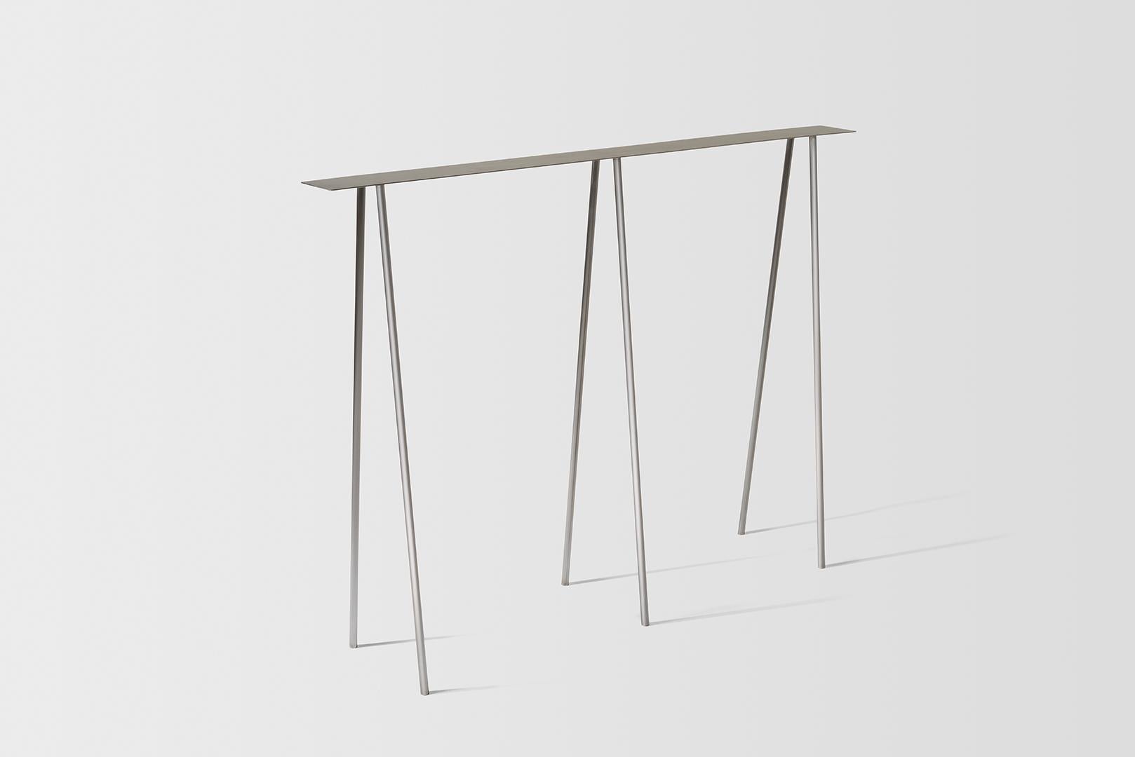 Where metal implies sturdiness, and calls for strong industrial motifs - the I/ the H, the beam / the cross, the Paper table is a play on our own sense of balance. 

It questions the thinness of both surface and structure, in order to reach their