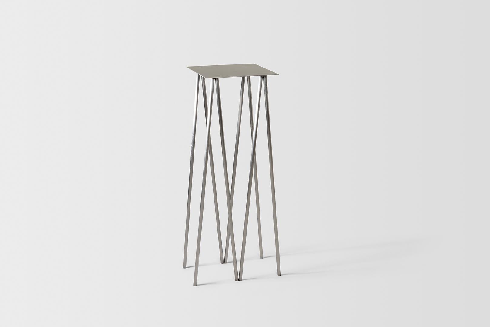 Where metal implies sturdiness, and calls for strong Industrial motifs - the I/ the H, the beam / the cross, the Paper Table is a play on our own sense of balance. 

It questions the thinness of both surface and structure, in order to reach their