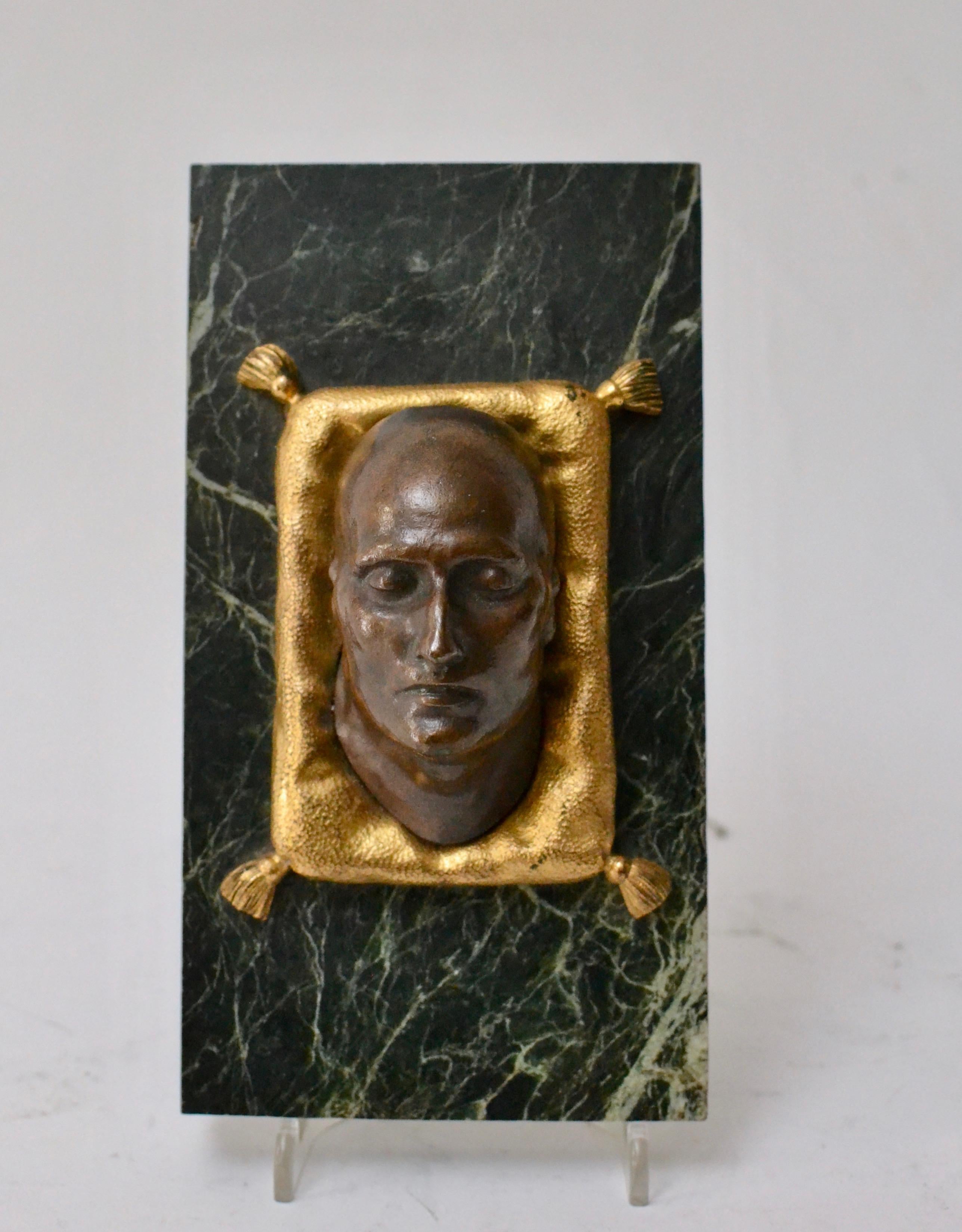 A paper weight with a patinated bronze of Napoleons death mask on a green marble base, France, early 19th century.