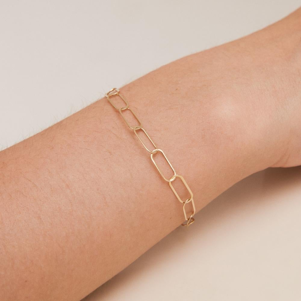 Unveiling the 14K Solid Gold Paperclip Layering Chain Bracelet by ORENA Jewelry – a testament to modern opulence and sleek design. Each bracelet is handcrafted with precision, showcasing a unique interplay of light and luxury. A harmonious addition