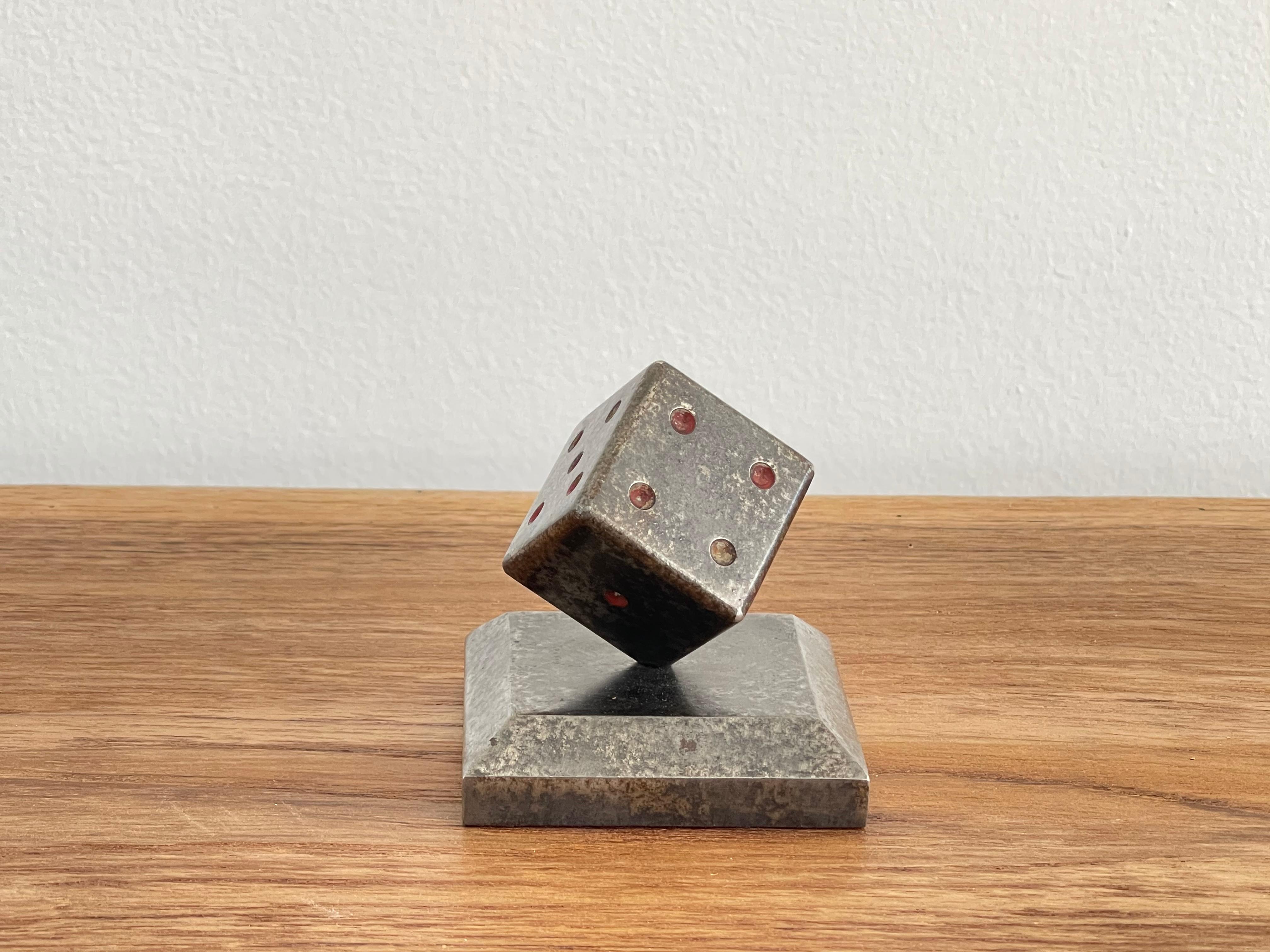 Wrought iron paperweight in shape of dice on square base with gunmetal patina. 
Heavy bronze.
Edgar Brandt circa 1930's - Famous French metal worker.