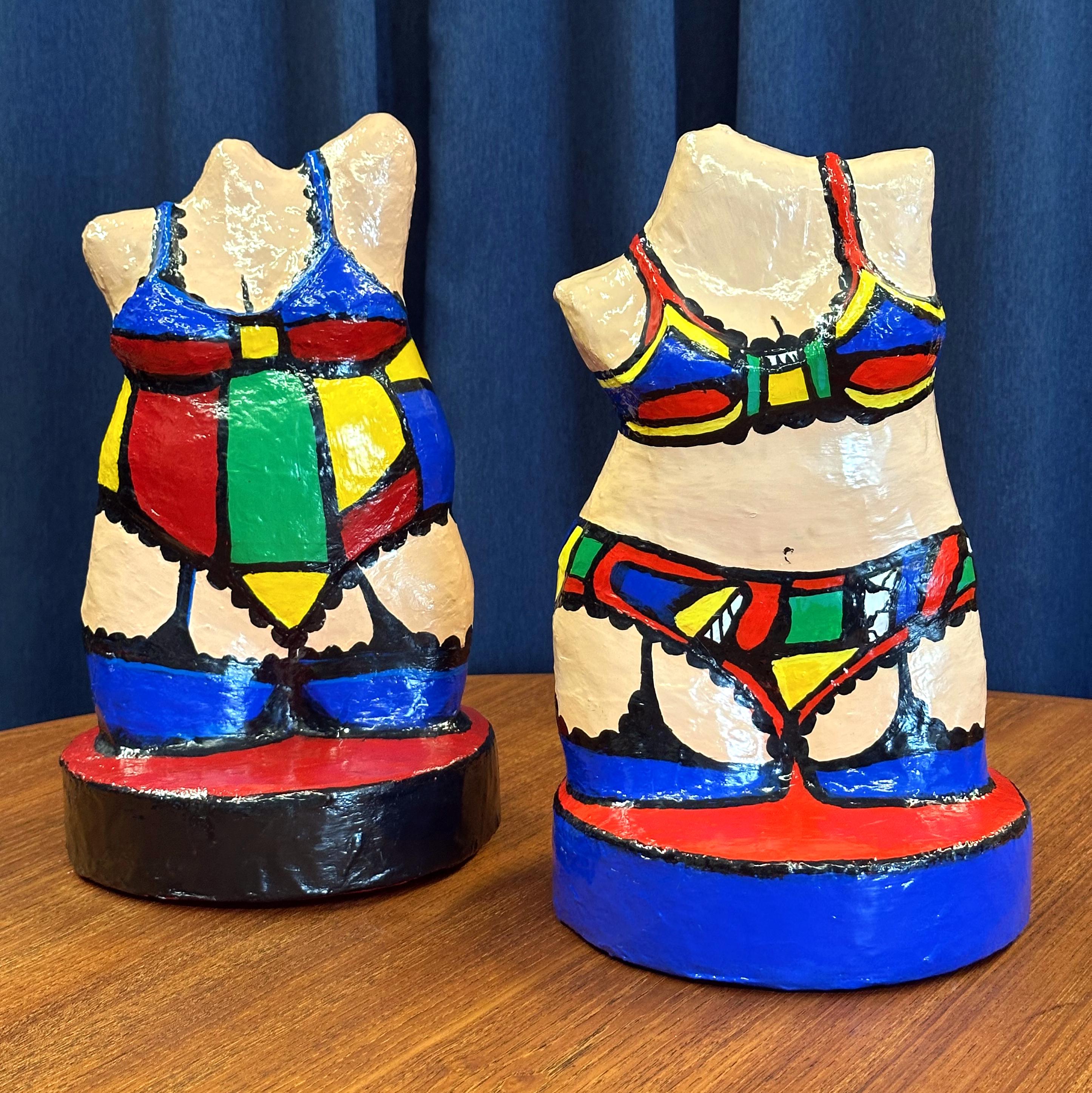 Add a burst of color and cheeky charm to your space with this vibrant 2002 pair of hand-painted papier-mâché sculptures by Denver artist Kathy Berenstein, signed and dated. These figures celebrate the female form with confidence and humor, adorned