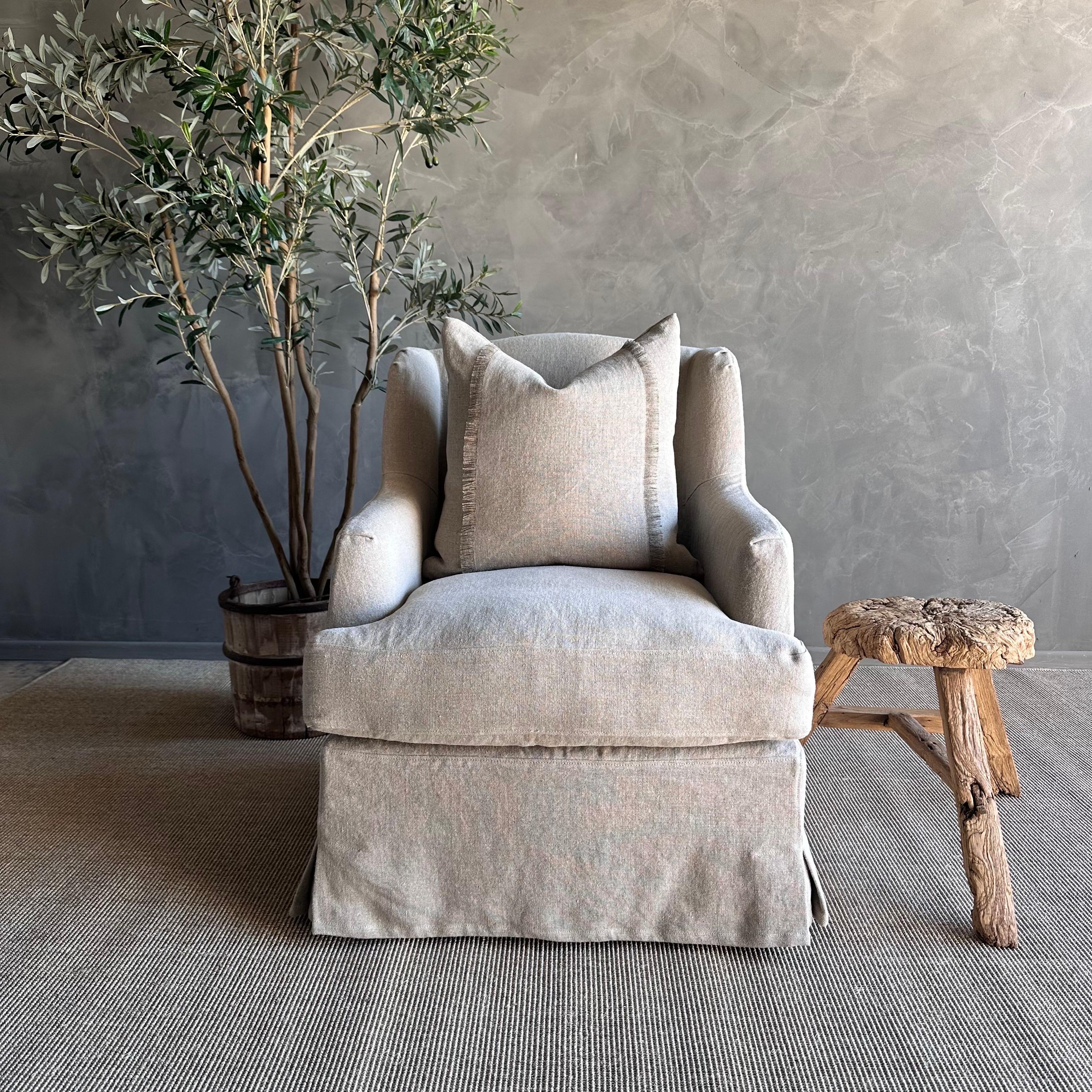 Introducing the Papillion Linen Wing Chair, a stunning piece that combines elegance and comfort. This chair is crafted with flax natural linen fabric, giving it a sleek and organic modern look. The slipcovered design makes it easy to maintain, as it