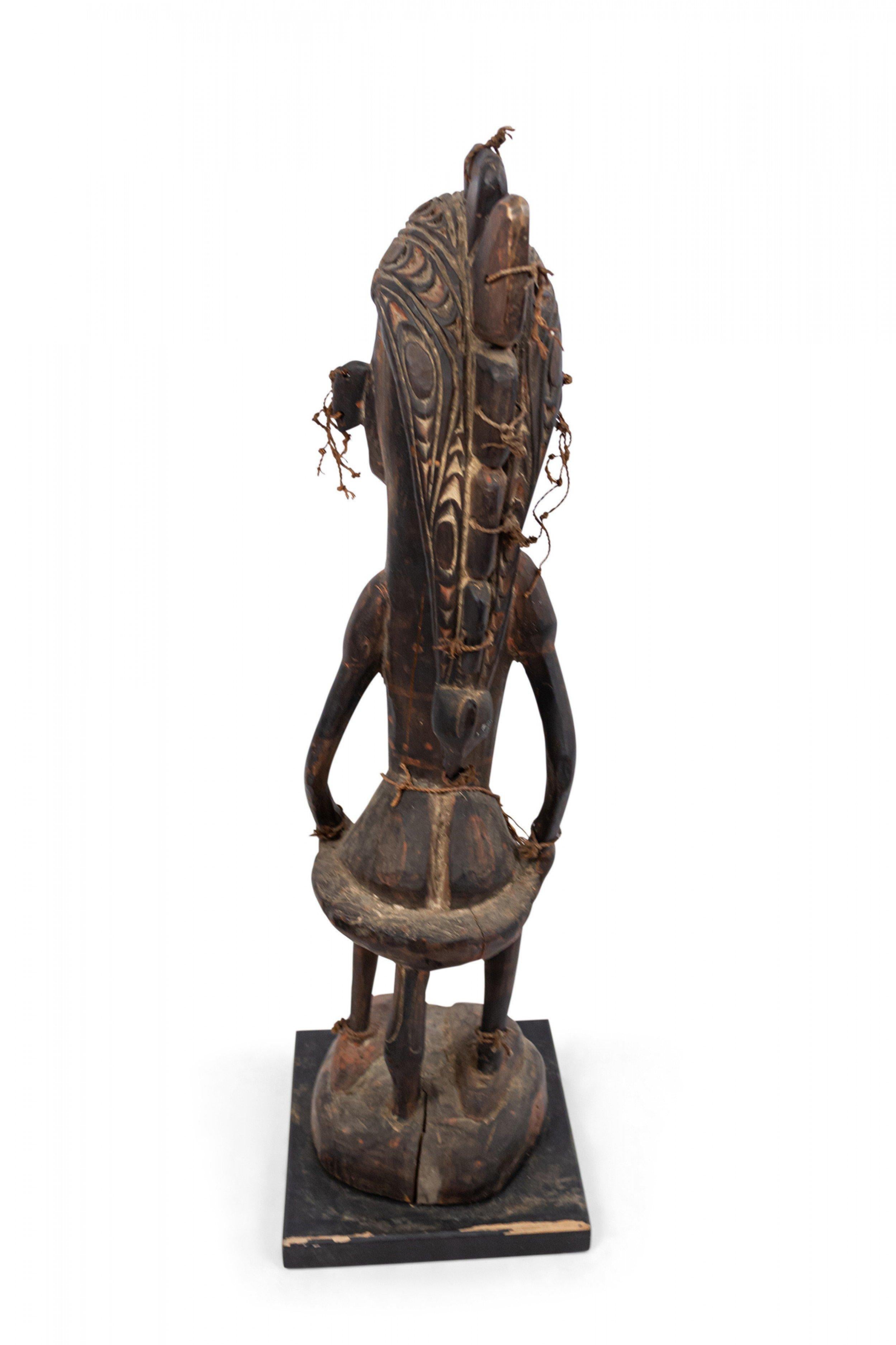 Papua New Guinean carved polychromed ancestral figure with fiber and shell detail