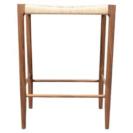 Der Papyri Hocker mit seinem Rahmen aus Schlitz und Zapfen und der handgeflochtenen Sitzfläche wird in Handarbeit aus recyceltem Papier und nachhaltig geerntetem Nussbaumholz hergestellt.

Die Sitzfläche besteht aus einer durchgehenden dänischen