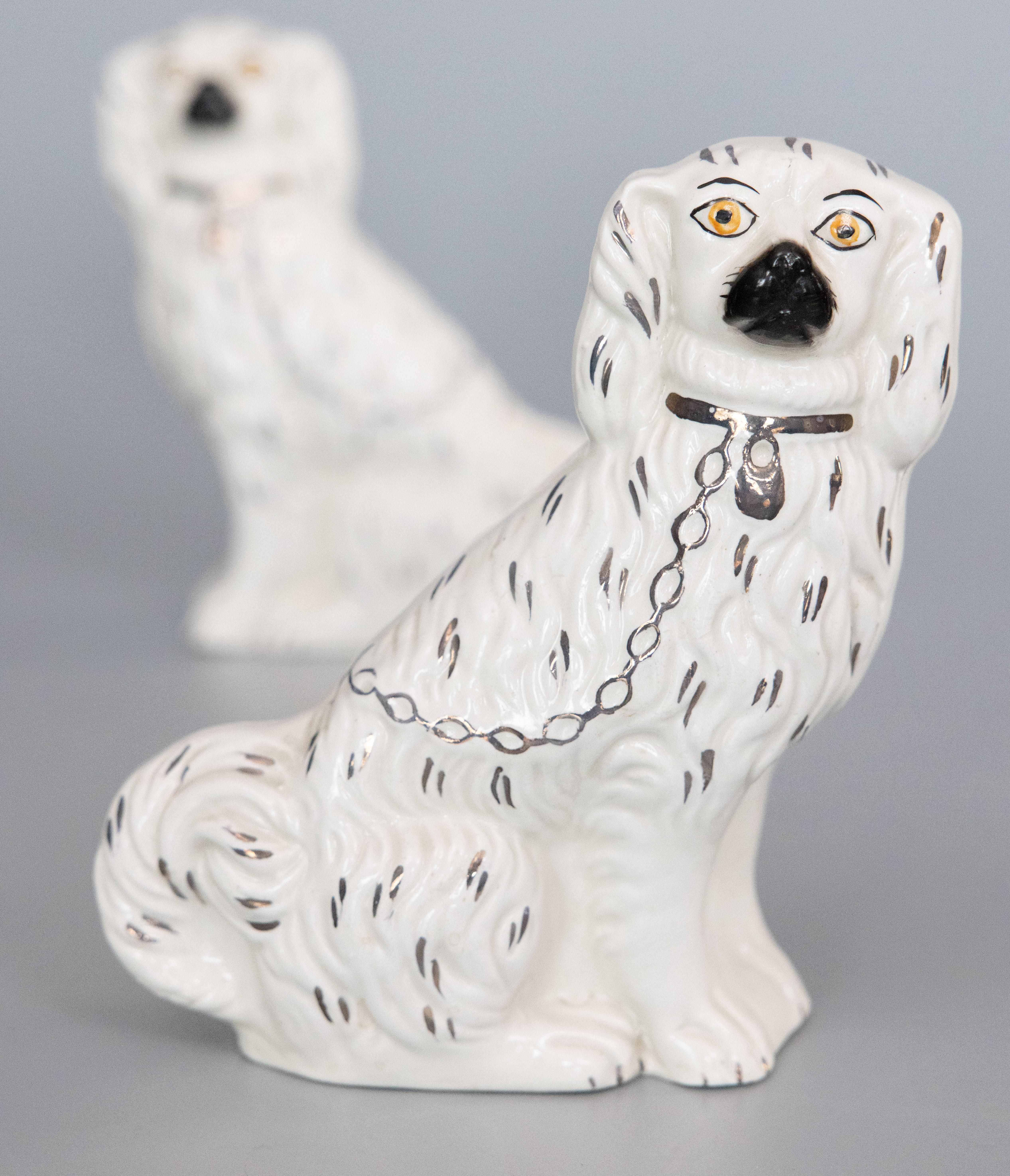 A fine pair of antique early 20th-Century English Staffordshire mantel dogs. Marked on reverse. These charming dogs are hand painted with lovely gilt details and sweet faces. They are the perfect Victorian pair of dogs for your mantel, bookcase, or