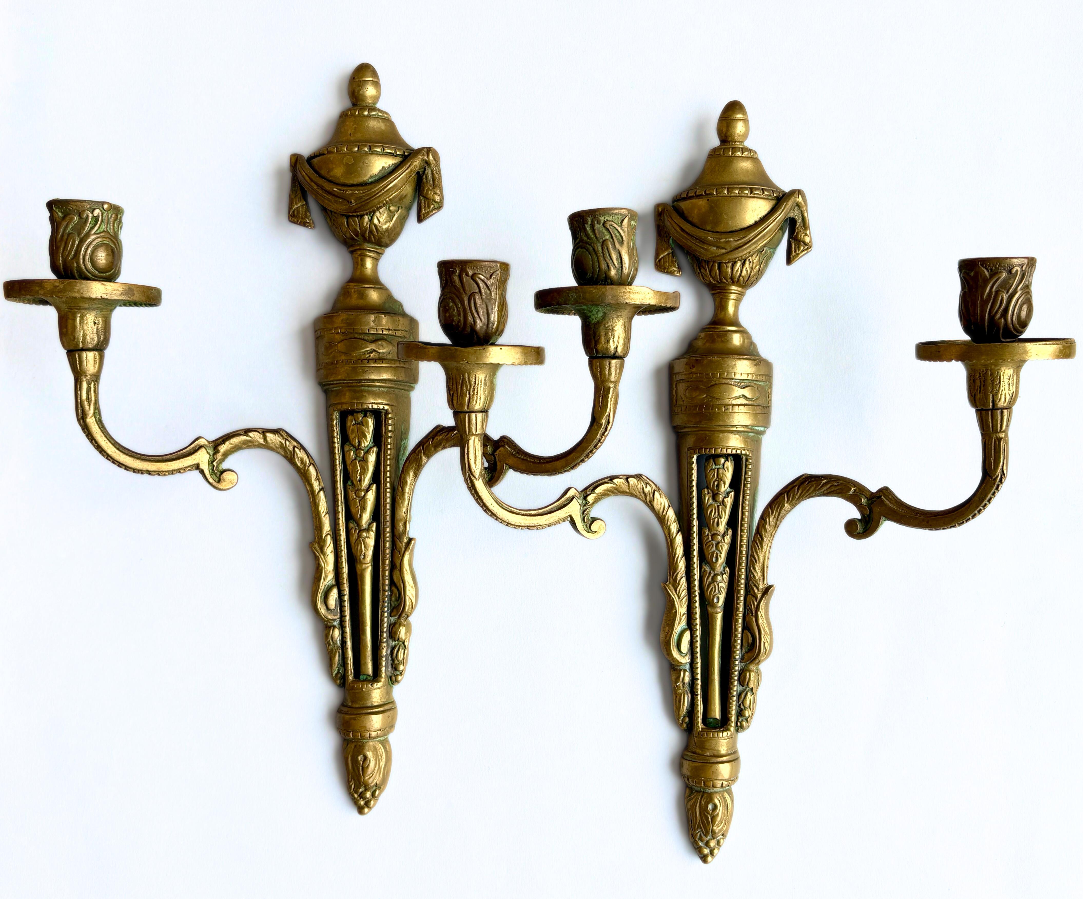 Eleganza classica francese. Una raffinata coppia di appliques francesi in bronzo modellato dei primi del '900, di provenienza francese e progettate in stile neoclassico / revival Luigi XVI. Ogni applique è caratterizzata da un terminale a forma di