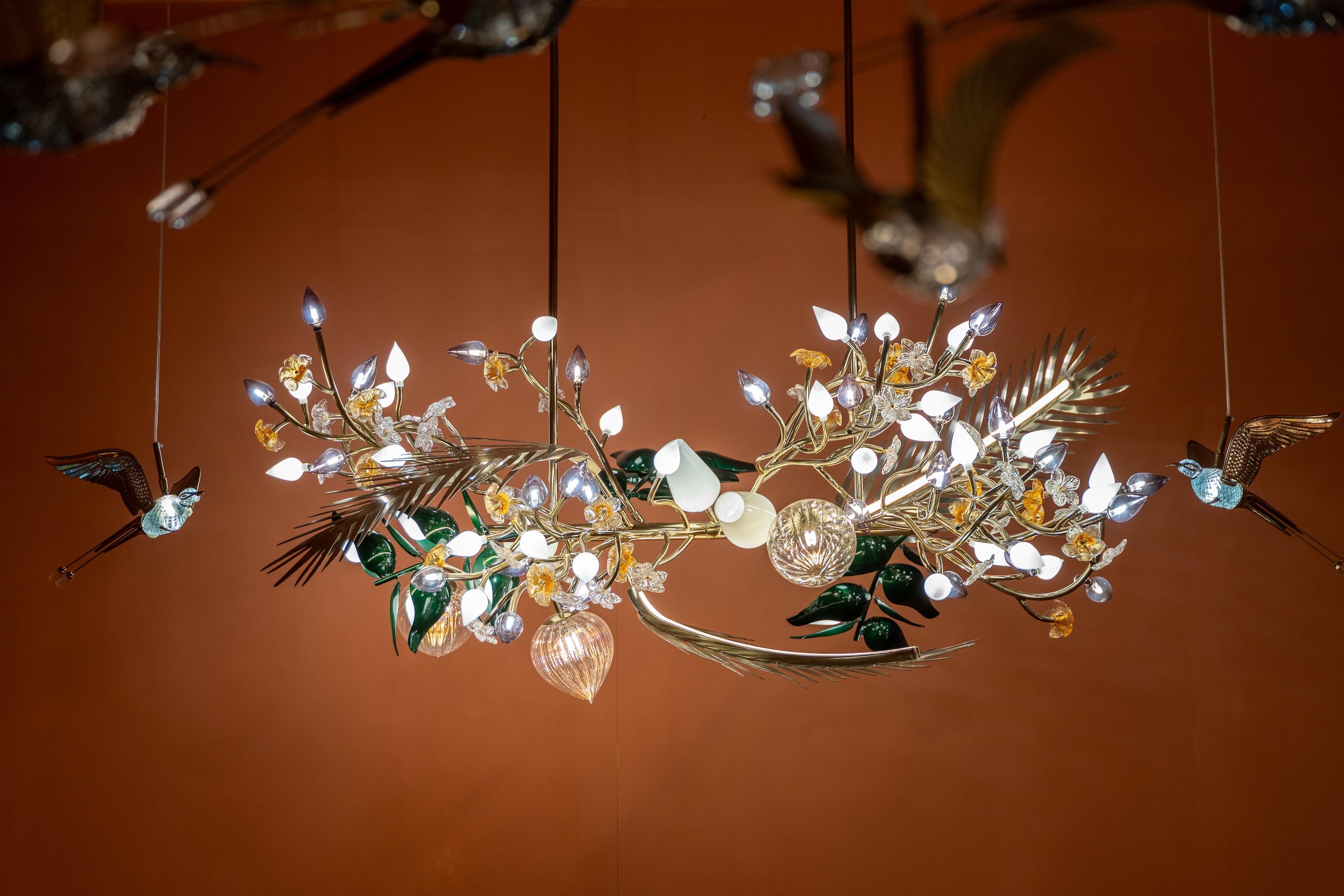Questo lampadario mozzafiato è un capolavoro di artigianato, ispirato alla bellezza della natura. Progettato per assomigliare a un albero rigoglioso in piena fioritura, presenta un'intricata disposizione di rami in ottone scolpiti a mano e ornati da
