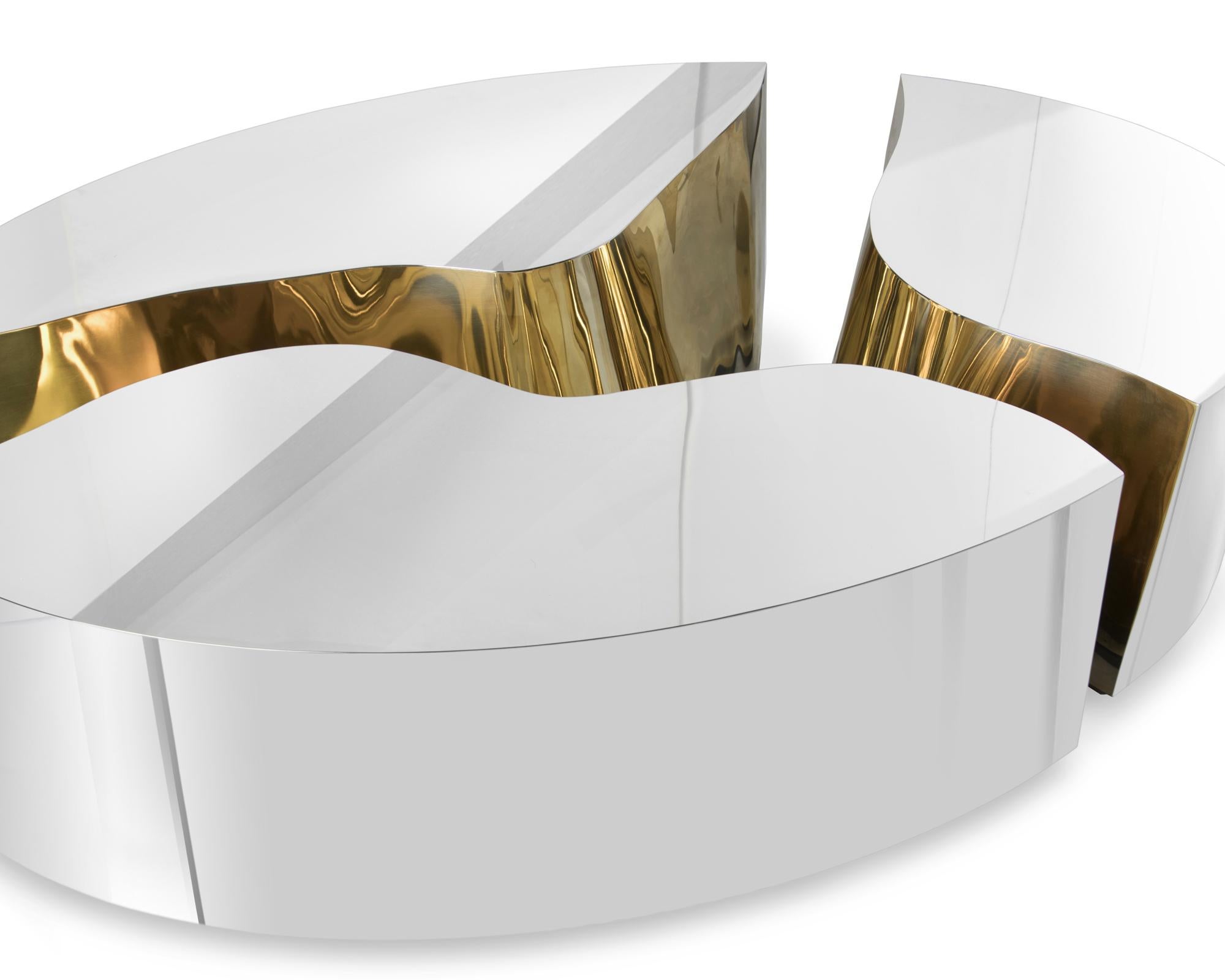 Coffee table paradise oval in polished stainless 
steel and with polished brass inside. On wood 
structure. Also available in poplar root and brass
and available in custom size and custom finishes.
