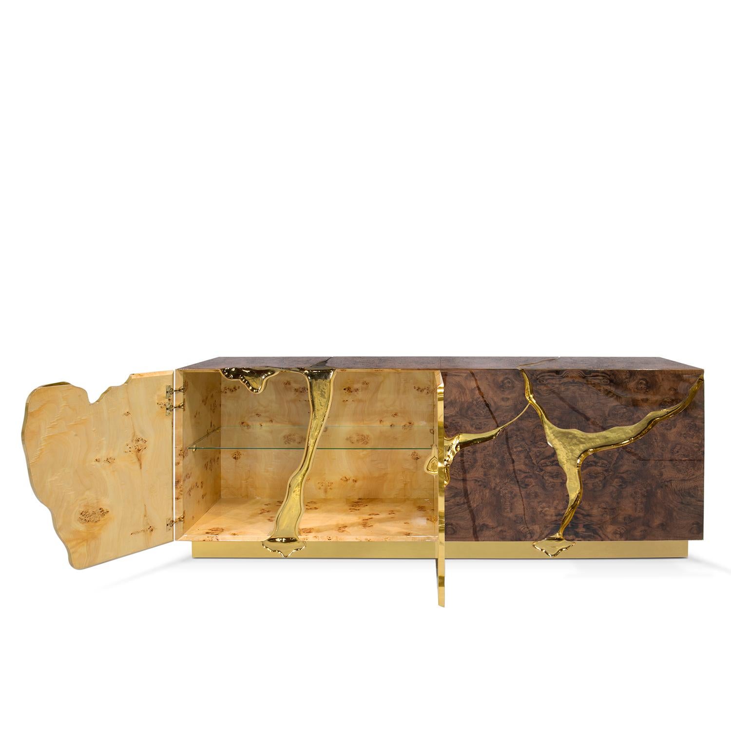 Aparador Paradise Nogal con estructura de madera revestida
con chapa de madera de nogal con exterior barnizado brillante y
con tallas de latón macizo en acabado pulido, con base de latón. 
Interior todo en madera de álamo. Aparador con 4 puertas y 1