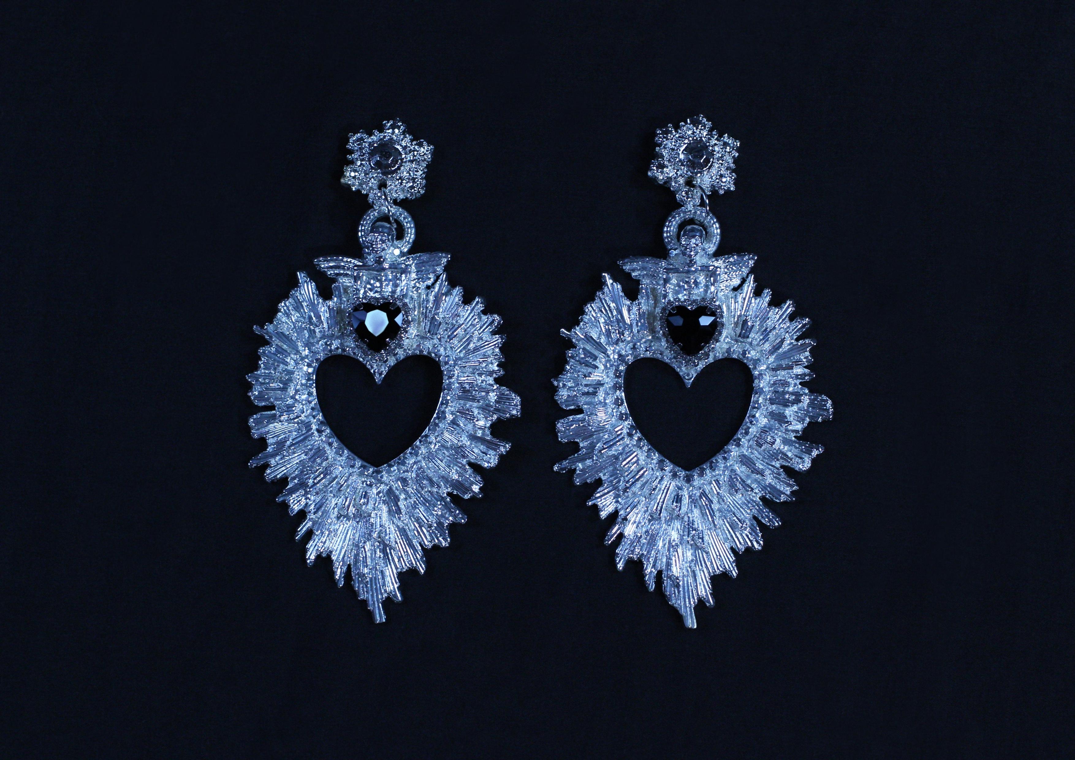 Paradiso Earrings by Angelis Blade

A celestial statement piece, the Paradiso earrings capture the essence of divine elegance and intricate craftsmanship. With a bold, cut-out heart at the centre, surrounded by meticulously detailed rays, each