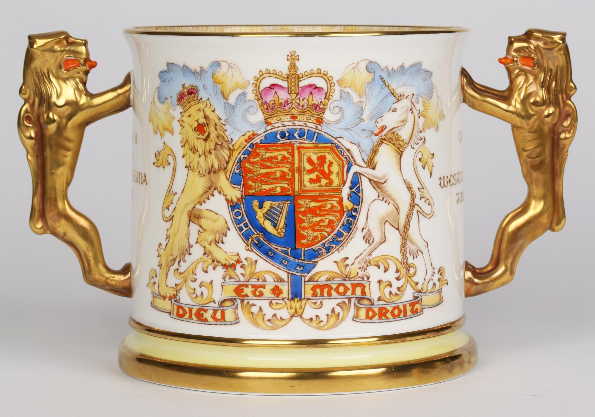 A very fine English Limited Edition porcelain twin handled tyg commemorating the Coronation of Queen Elizabeth II in 1953 and made by Paragon China. The large cylindrical shaped tyg stands on a wider stepped foot with rampant lion handles applied