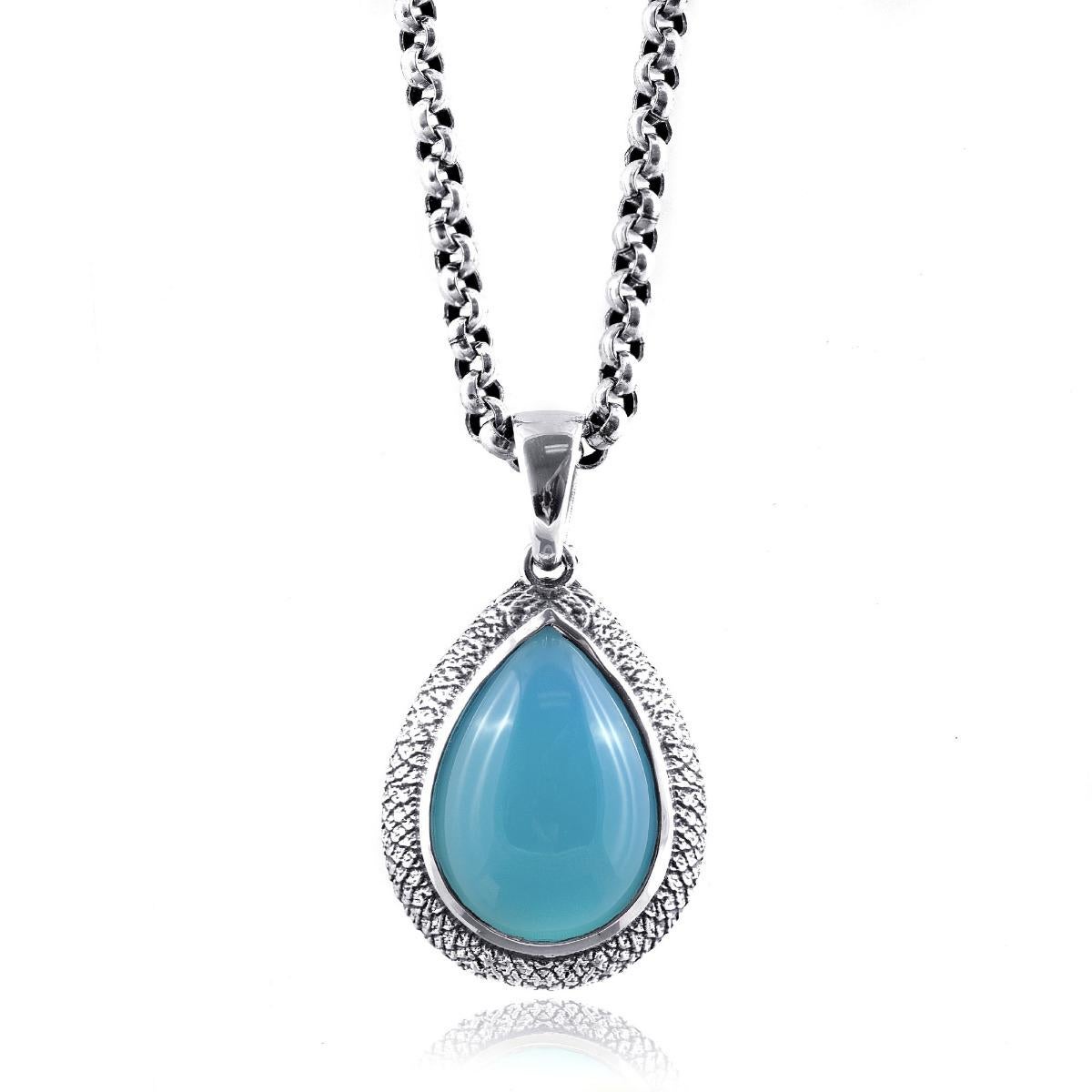 Scopri l'affascinante bellezza dell'agata color Paraiba con questo splendido ciondolo in argento. Questo squisito pezzo presenta una vibrante agata blu, perfettamente completata da una montatura in argento finemente lavorata. Ideale per aggiungere