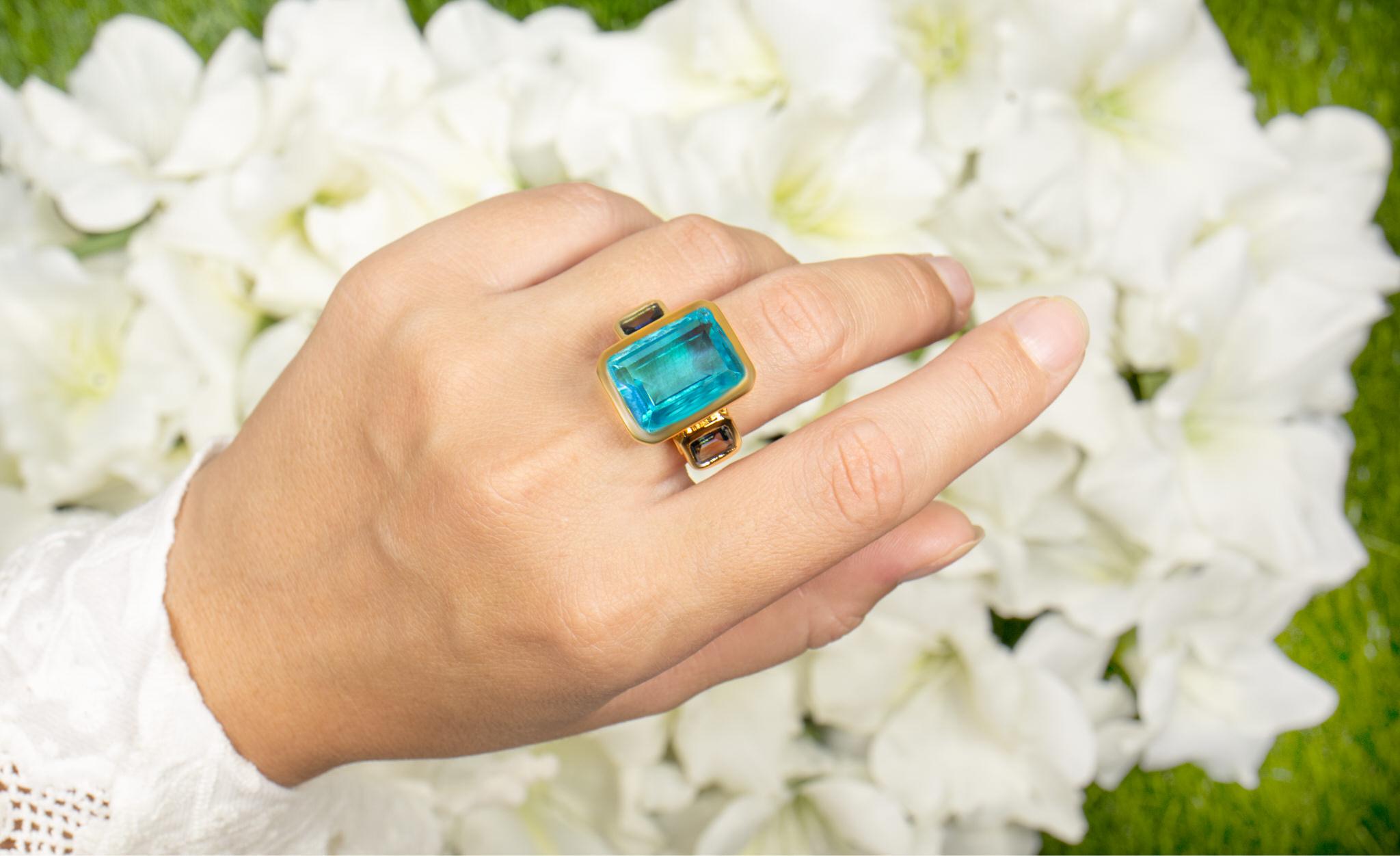It comes with the Gemological Appraisal by GIA GG/AJP
All Gemstones are Natural in Origin
Paraiba Quartz = 15.25 Carats
2 London Blue Topazes = 2.40 Carats
Metal: 18K Yellow Gold Plated Sterling Silver
Ring Size: 7* US
*It can be resized