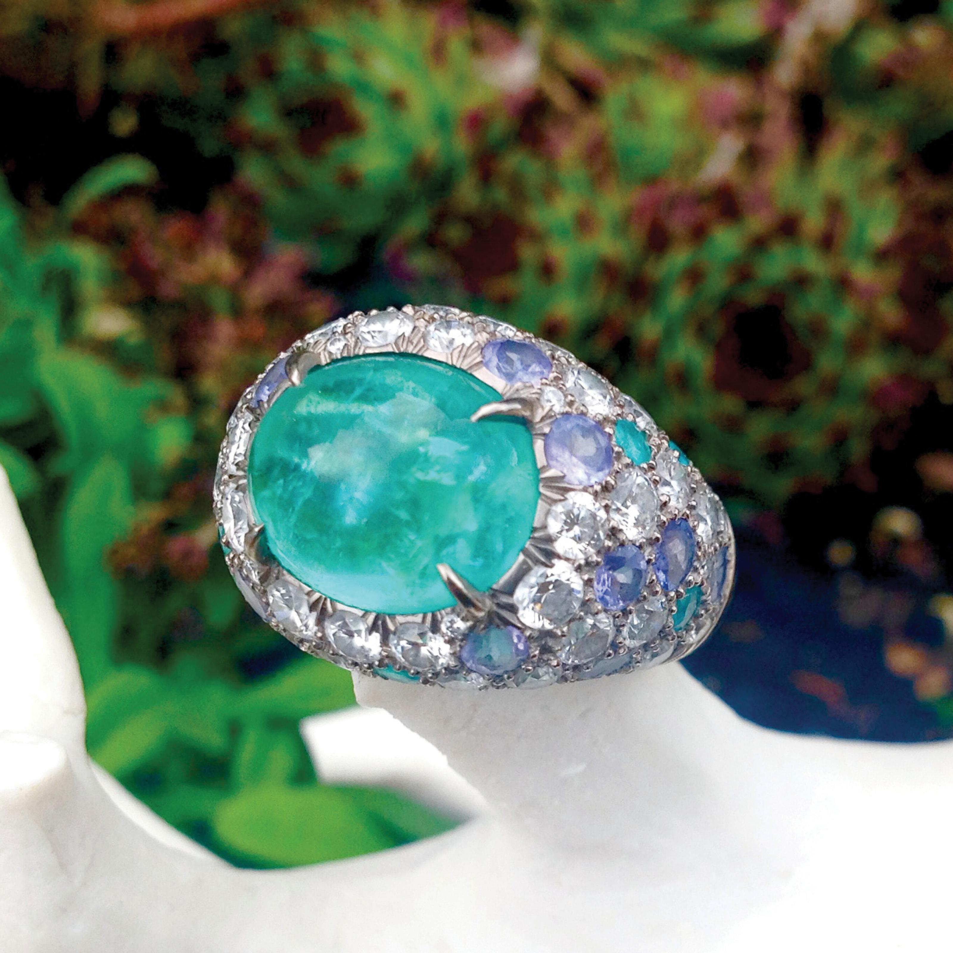 The radiance of this Cabochon Cut Paraiba Tourmaline, from Mozambique, are showcased by more Paraiba Tourmalines as well as Diamonds and Blue Sapphires from Brazil.

Paraiba Tourmaline 5.9 Carat, 11.76mm x 9.53mm

In the Band: Diamonds 2.25 Carat,