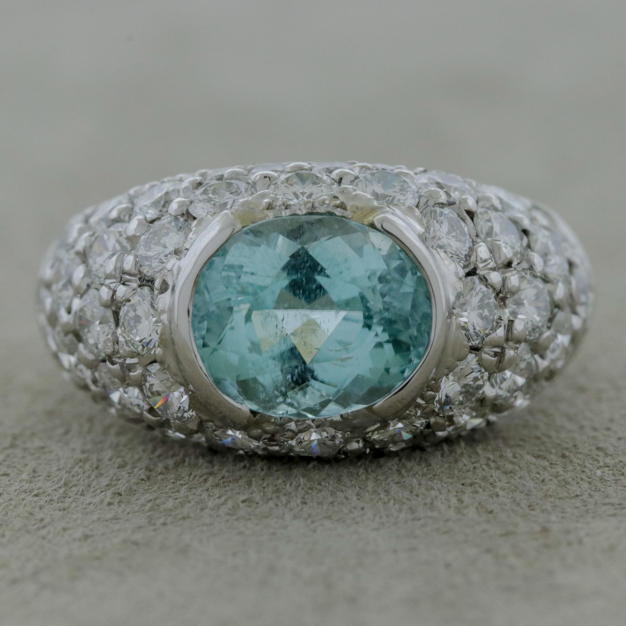 A lovely ring with a fine and rare gemstone. It is an oval-shaped Paraiba tourmaline weighing 2.53 carats. It has an electric greenish-blue color which Paraiba is known for and is certified by the GIA as natural. It is accented by 3.11 carats of