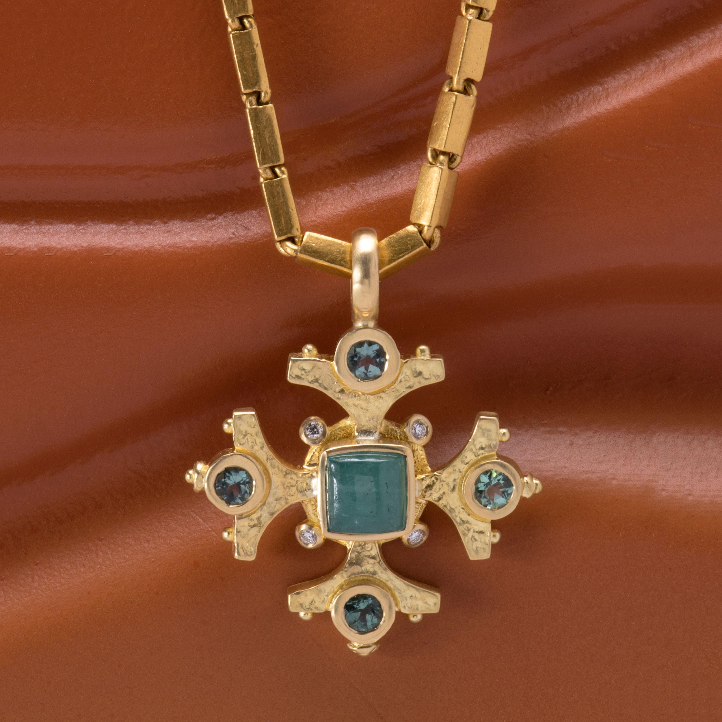 A quartet of sea foam green tourmalines 1.12tcw pay homage to a stunning soft Paraiba tourmaline 2.68cts which centers this handcrafted Maltese Cross pendant. A hammered satin finish on this 18k gold pendant is enhanced at four points with twinkling