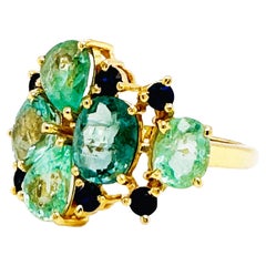 Runder Ring aus 18 Karat Gelbgold mit Paraiba-Turmalin in Mischform und blauem Saphir