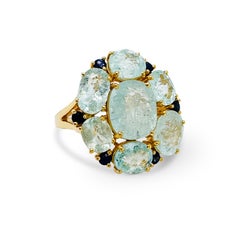 Anillo redondo de turmalina paraiba ovalada y zafiro azul en oro amarillo de 18 quilates